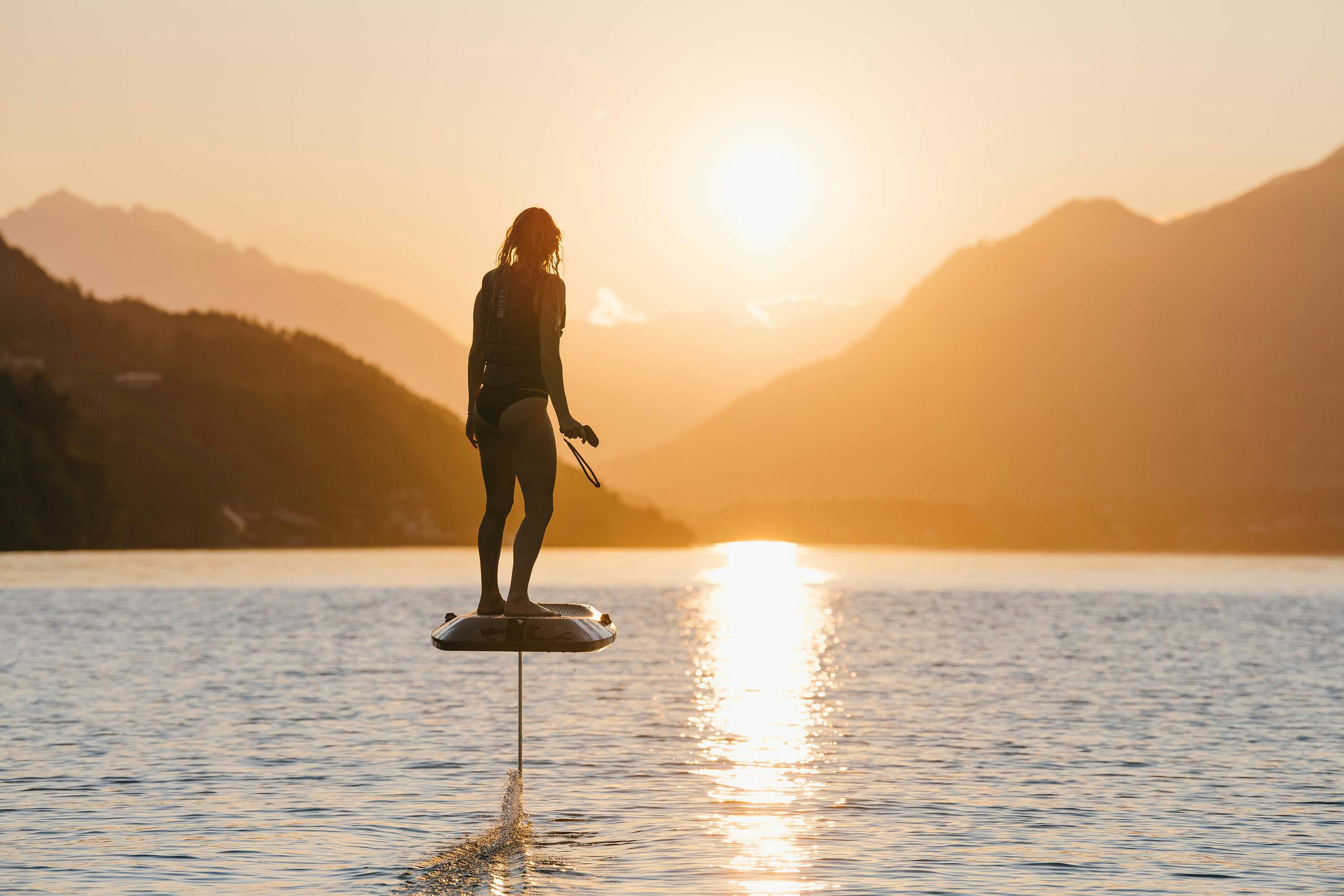 aerofoils action shot of a woman using the water hover board during sunset