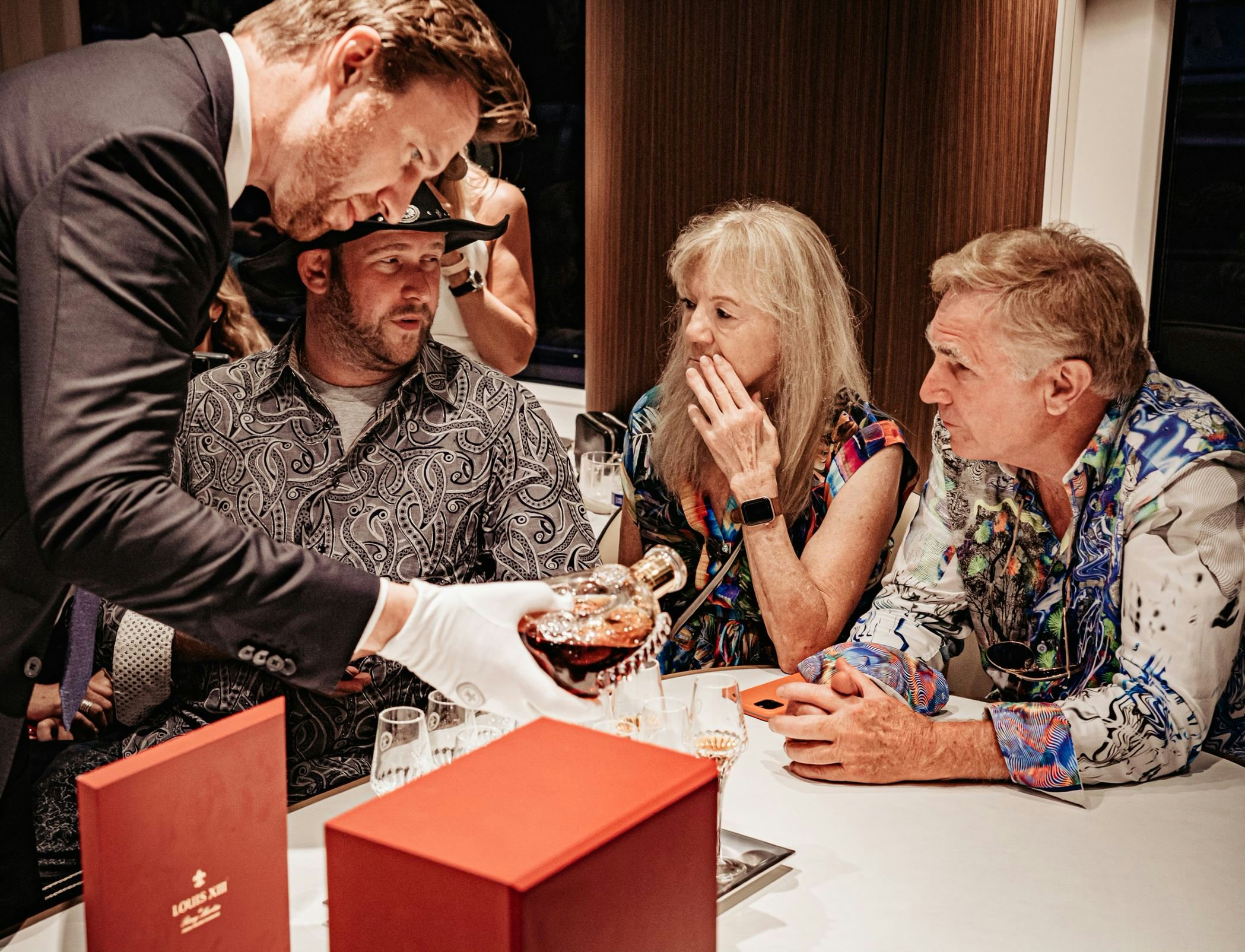 man pouring Louis XIII aboard a yacht