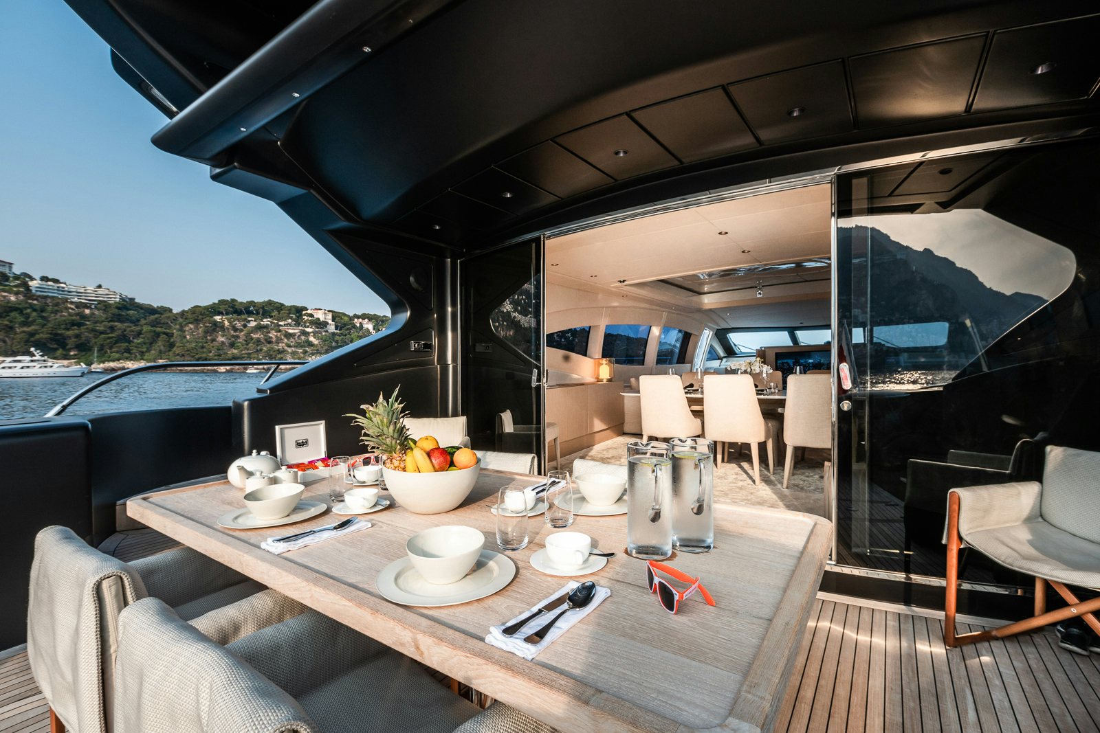 A pristine outdoor dining setup on the Mangusta 108 yacht, ready for guests to enjoy a meal with ocean views.