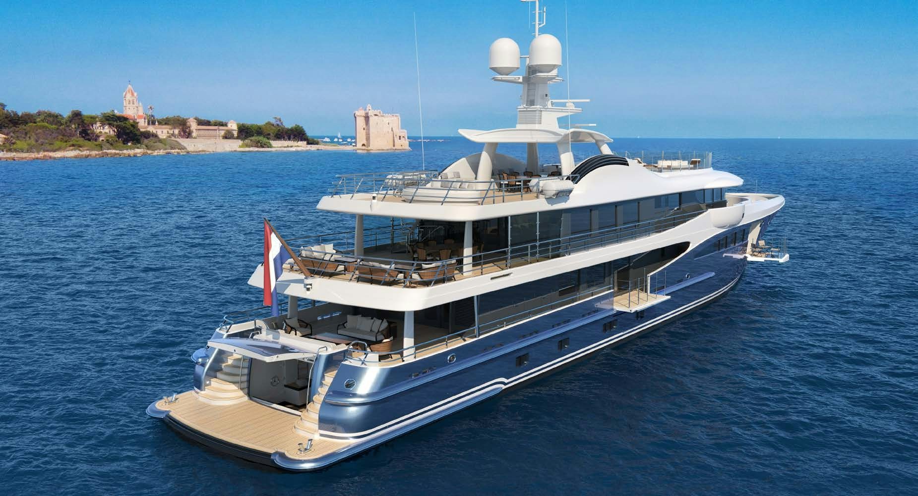 The Amels 180 Superyacht anchored near a picturesque coastal fort under clear skies.