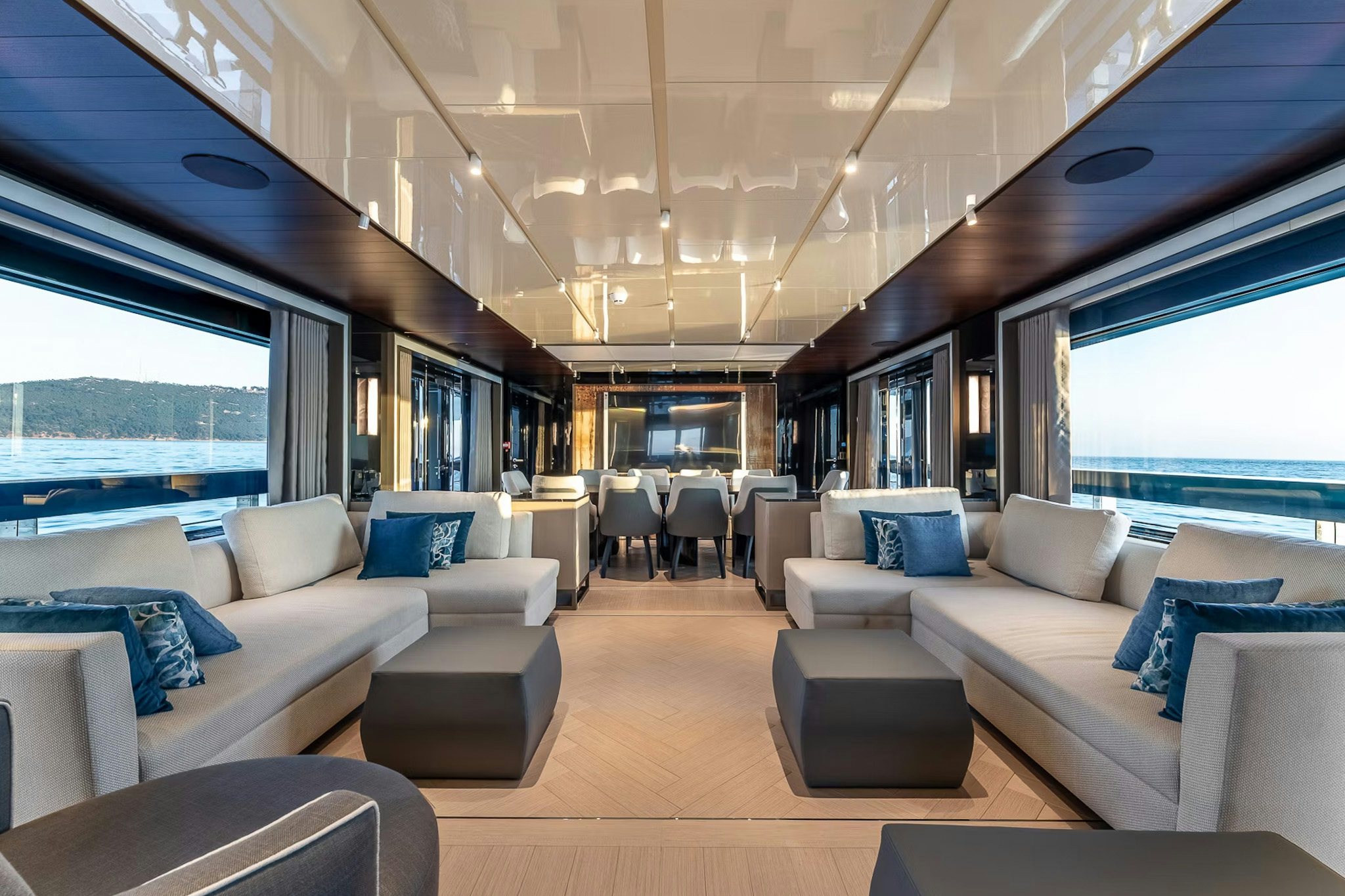 Interior of 34.6m AES explorer yacht MERELEY I showing Hot Labâdesigned main salon with panoramic sea views, neutral sofas, and a dining area for 10 guests.
