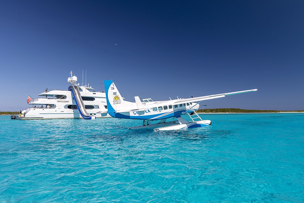 Side profile of MILESTONE on the water with private plane