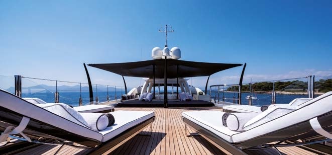 Sun loungers line the sun deck of the Amels 180 Superyacht under a minimalist style shade structure.
