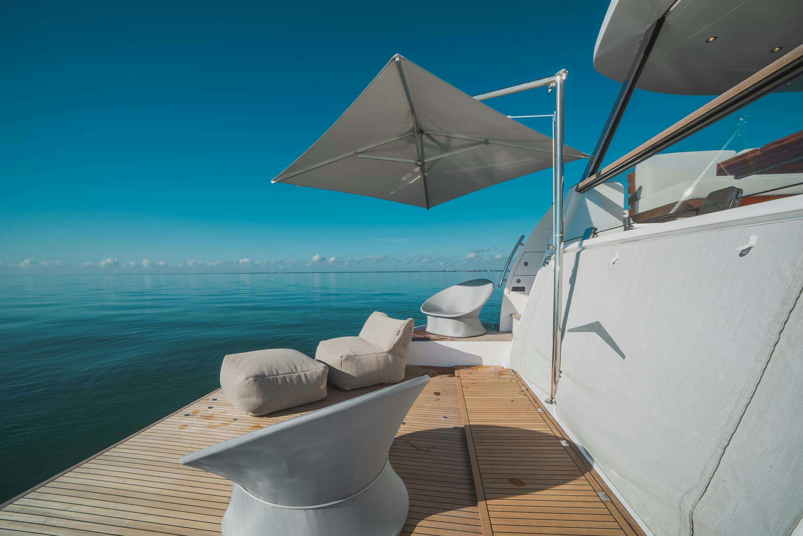 Charter yacht's swimming platform with furniture and umbrella