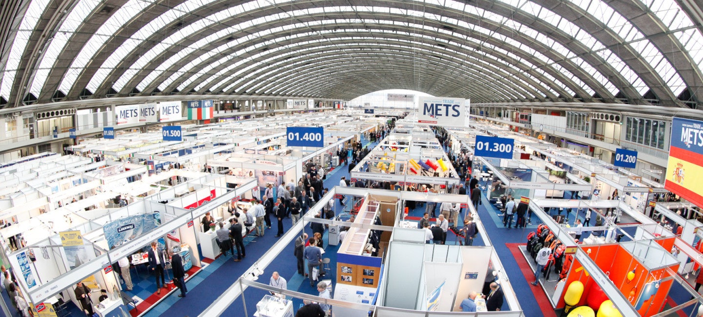 Overhead view of METSTRADE 2024, with crowded aisles between exhibitor booths under a large arched venue roof.