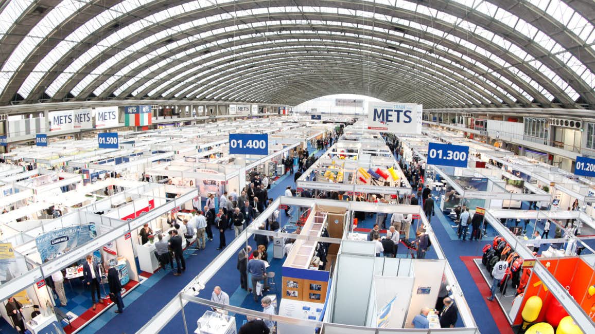 Overhead view of METSTRADE 2024, with crowded aisles between exhibitor booths under a large arched venue roof.