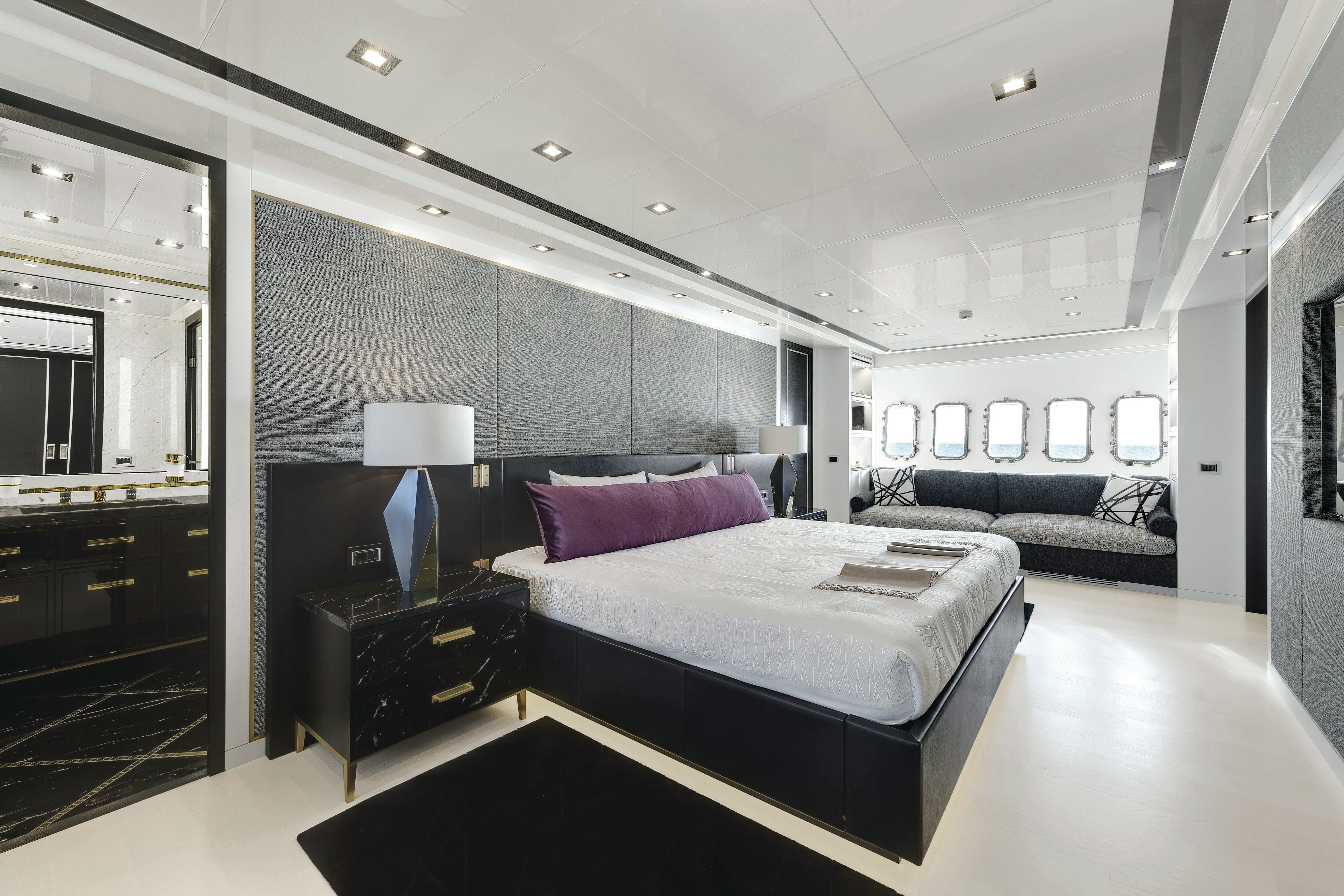 Modern Maritime Luxury: The Master Suite of Mangusta 165 Sophisticated master bedroom inside the Mangusta 165 yacht featuring a king-size bed, elegant furnishings, and natural light from portholes.