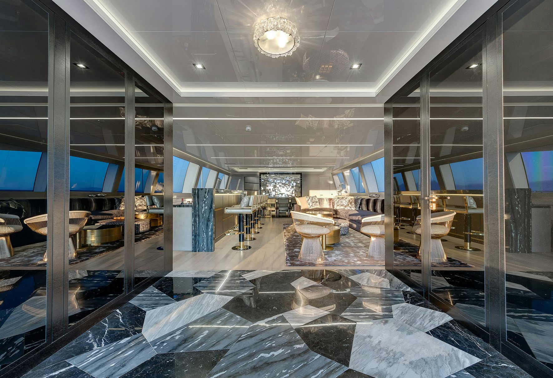 Refined Interior Splendor: Mangusta 165 Salon An opulent salon interior aboard the Mangusta 165 yacht, featuring mirror-like marble floors, stylish seating, and panoramic windows.