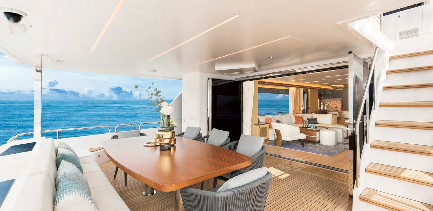 View from the aft deck dining area into the luxurious salon of the Horizon FD 80 yacht.
