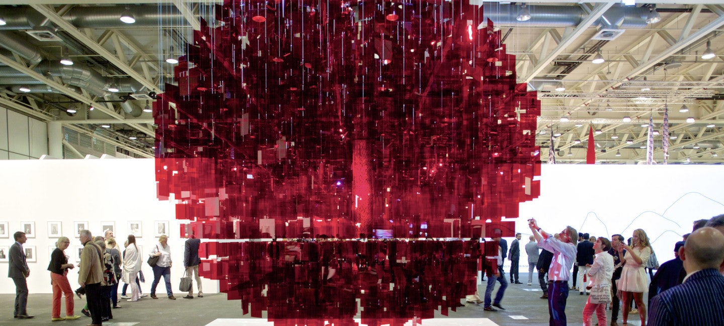 Mesmerizing art pieces on display at Art Basel Switzerland, surrounded by a diverse crowd of art enthusiasts and visitors exploring the gallery.