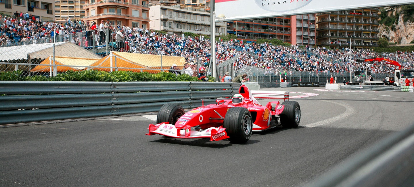 Formula 1 Monaco Grand Prix race car zooming past luxury superyachts