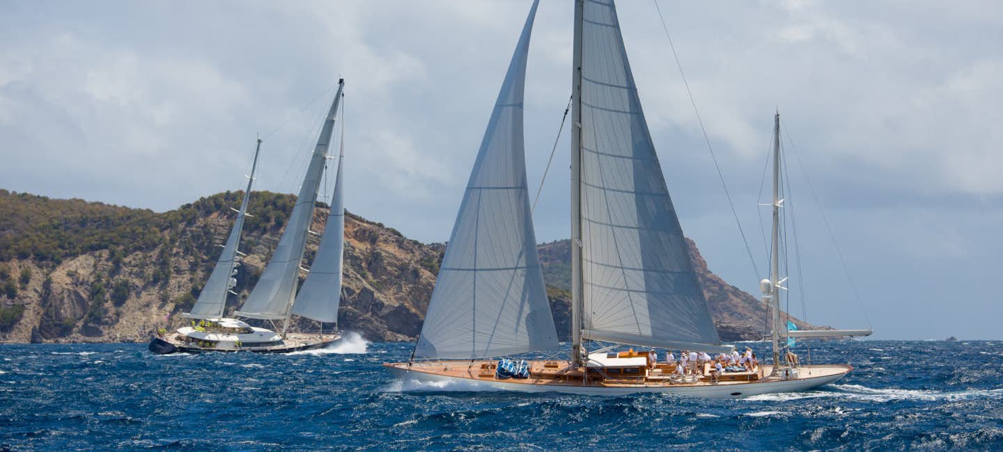Sailing yachts racing with determination on a windy and wavy day during the prestigious St. Barths Bucket regatta.
