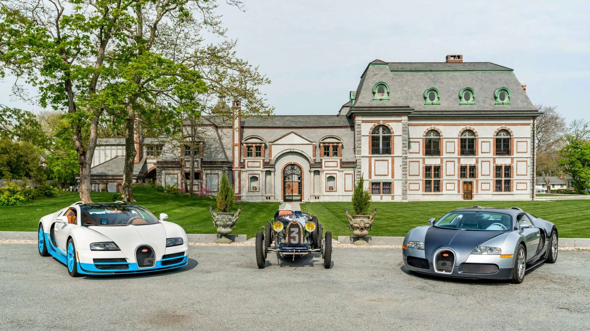 A stunning display of two modern Bugattis and a classic model in front of an elegant mansion in Newport during the Audrain Newport Concours & Motor Week