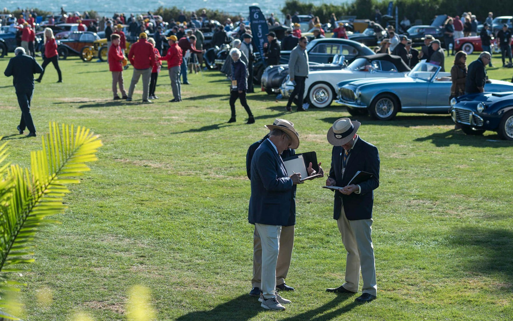 Judges taking notes as they view the cars on display at Audrain&#039;s Newport Concours Motor Week