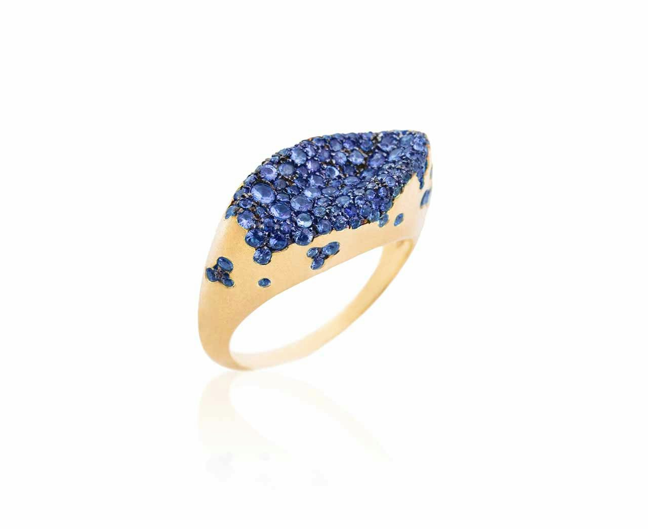 A gold ring encrusted in electric blue sapphires on a white background