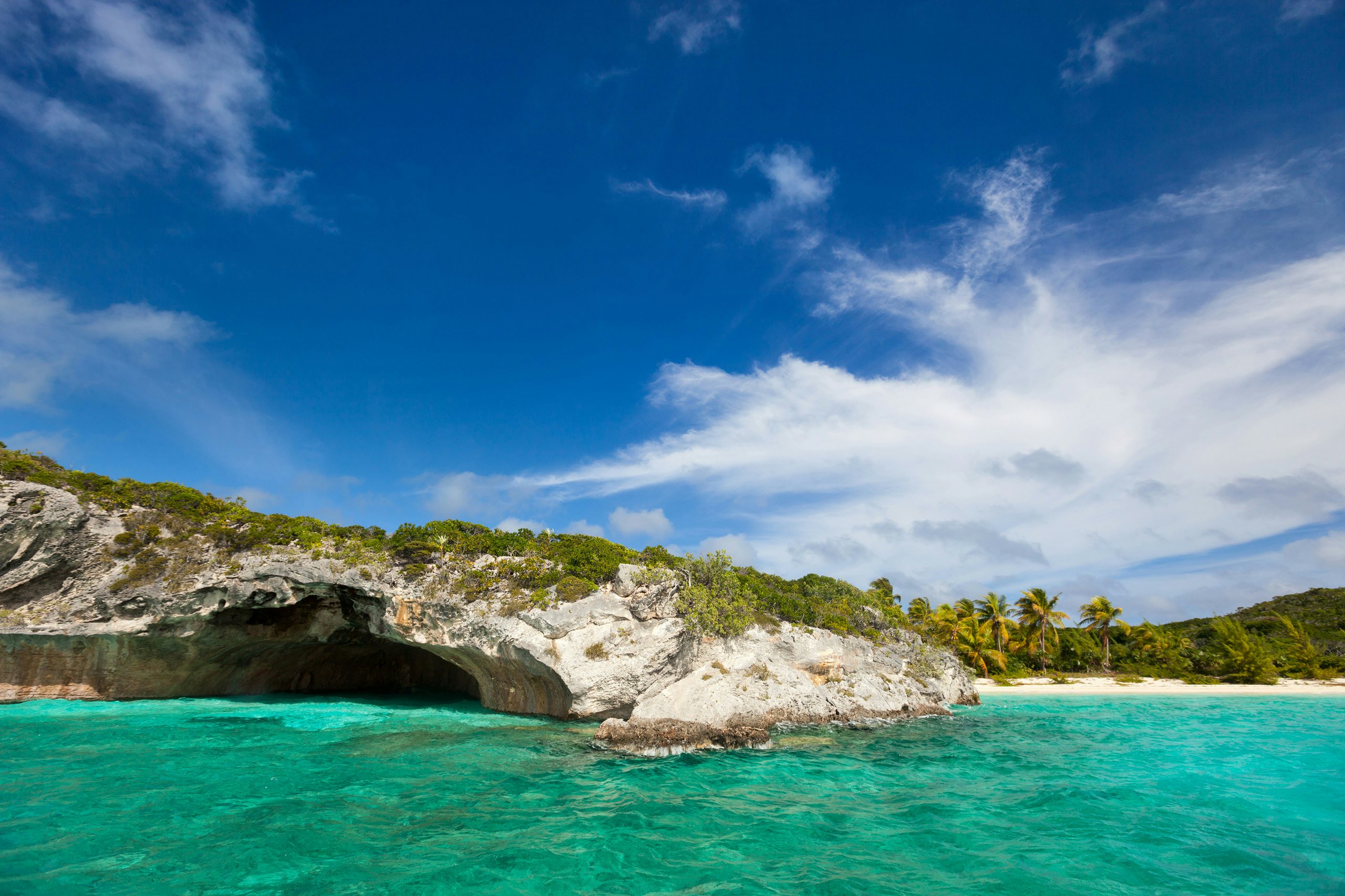 A tranquil scene during a Bahamas Yacht Charter, featuring rocks gracefully finishing in turquoise waters in a secluded cove in the Exumas.