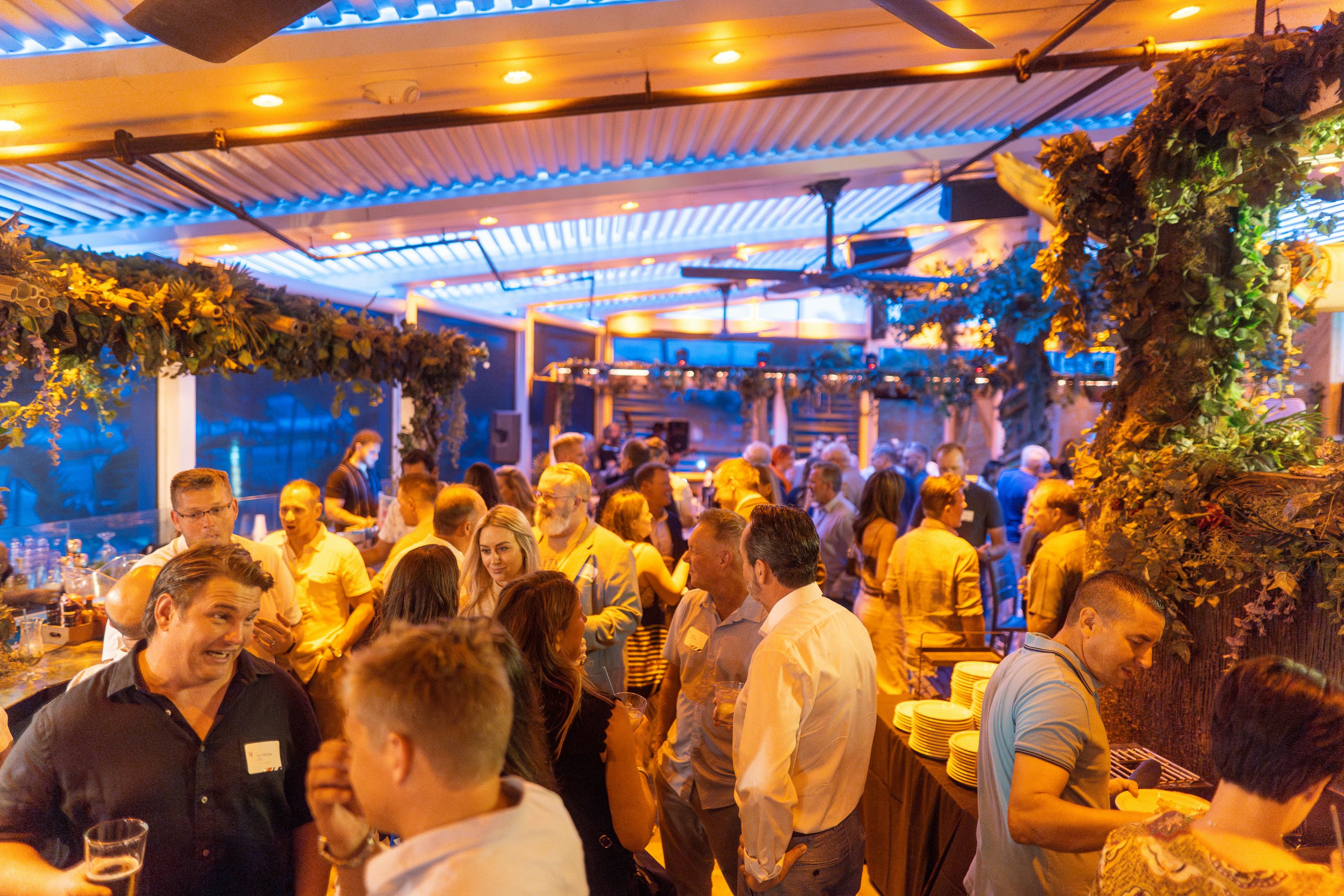 N&J FLIBS 2024 captains event at Bo's beach house with guests looking happy and chatting