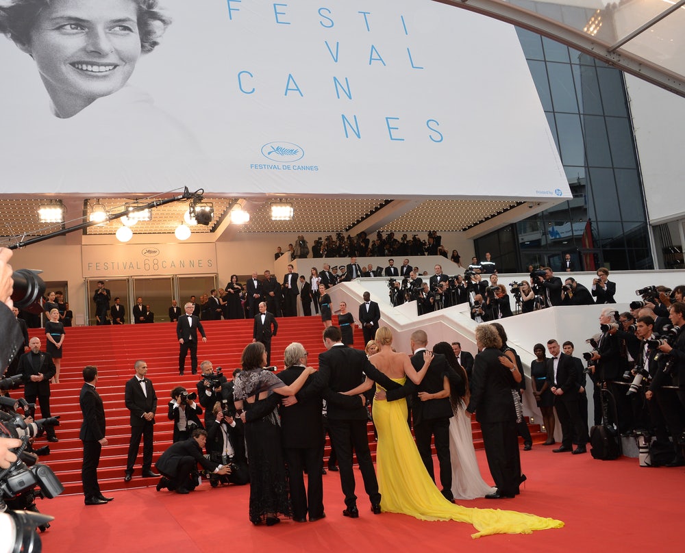 A dazzling scene featuring VIPs on the red carpet during the Cannes Film Festival, striking poses and capturing glamorous moments through the lens of photographers.