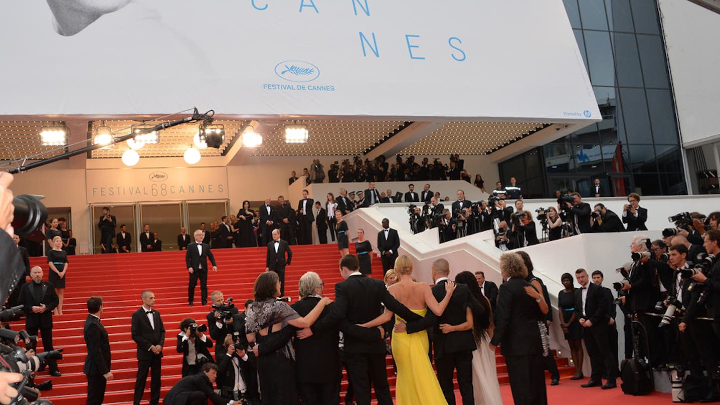 A dazzling scene featuring VIPs on the red carpet during the Cannes Film Festival, striking poses and capturing glamorous moments through the lens of photographers.