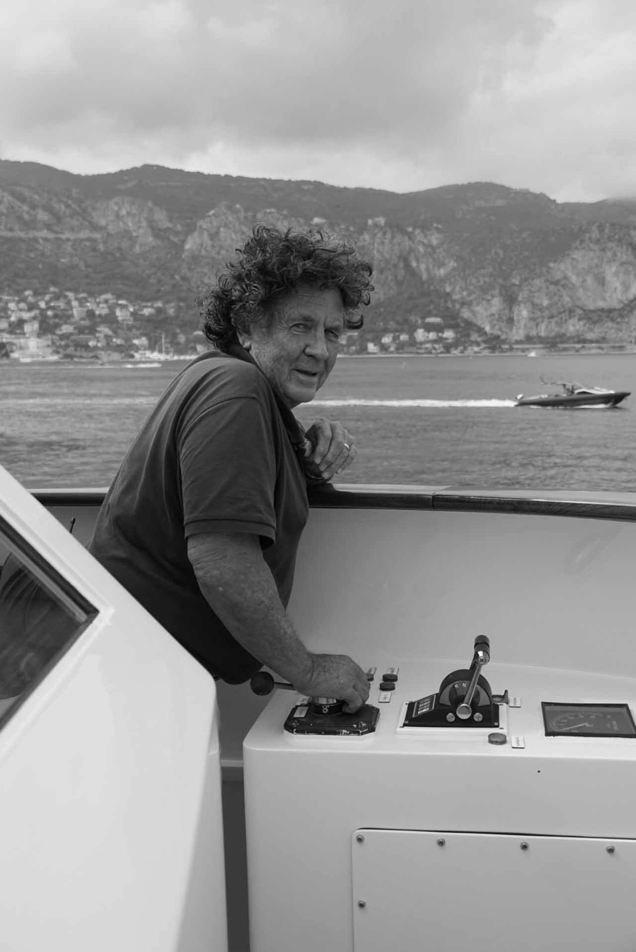 Captain Neil Batt looking at the camera, piloting SYNTHESIS 66 in the bay of Beaulieu-sur-Mer