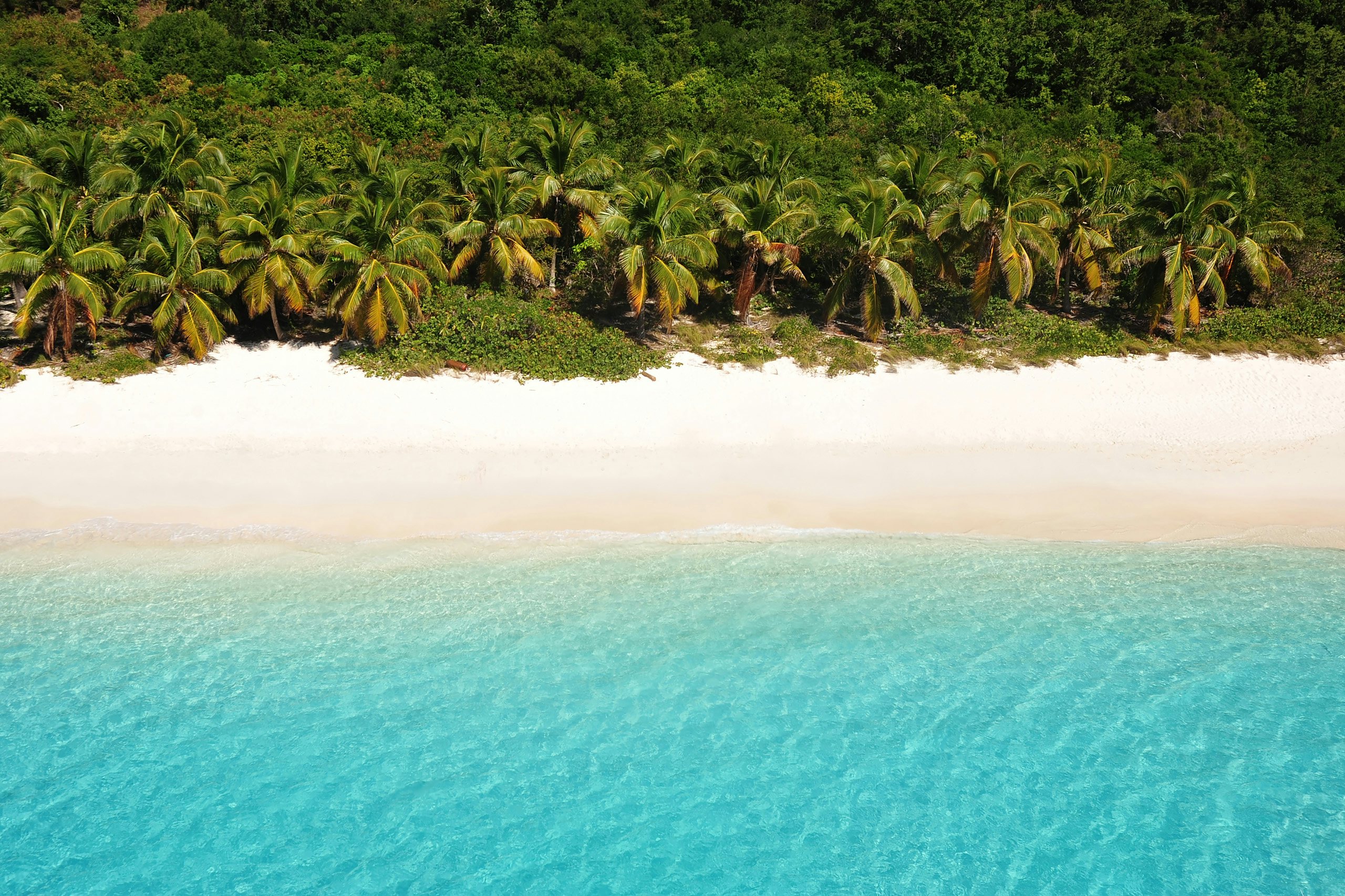 BVI Luxury Yacht Charter Serenity: Aerial View of Cooper Island's Quiet Beach A tranquil aerial view of Cooper Island in the BVI, Caribbean—a secluded and serene beach with white sand and bright blue waters, inviting bliss on your Luxury Yacht Charter.