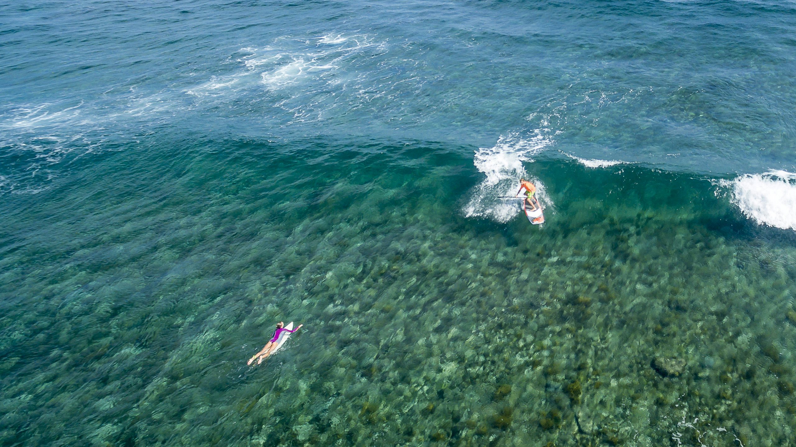A mesmerizing skyview of crystal clear waters in the Caribbean, Barbuda, with people enjoying the pristine beauty thanks to their yacht charter with N&J.