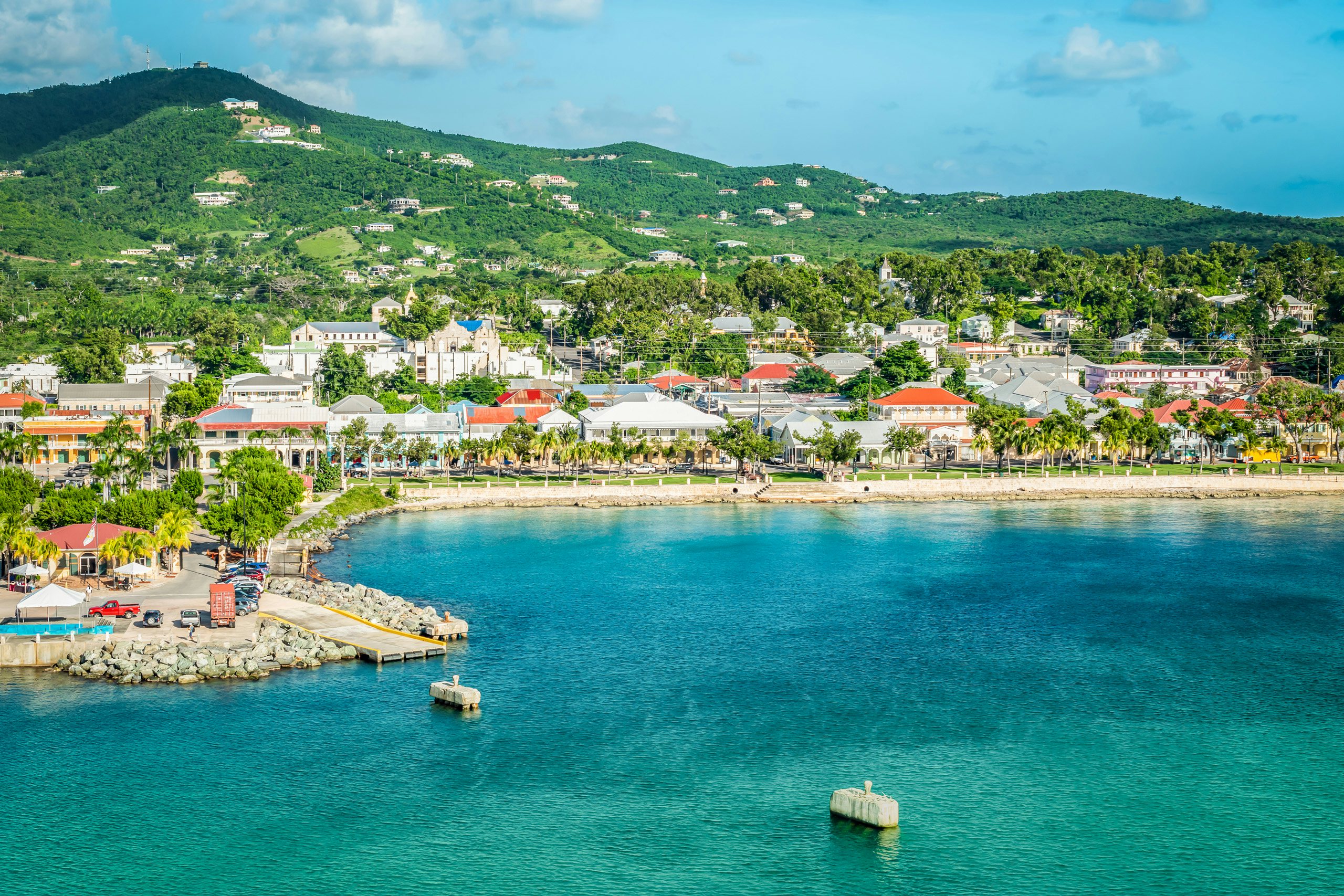 Leeward Islands Superyacht Charms: Aerial View of Frederiksted, Saint Croix, US Virgin Islands Coast An exquisite aerial view of the coast in Frederiksted, Saint Croix, US Virgin Islands—a perfect destination for Leeward Islands Superyacht Charter, featuring blue waters, white sand, and lush green vegetation.