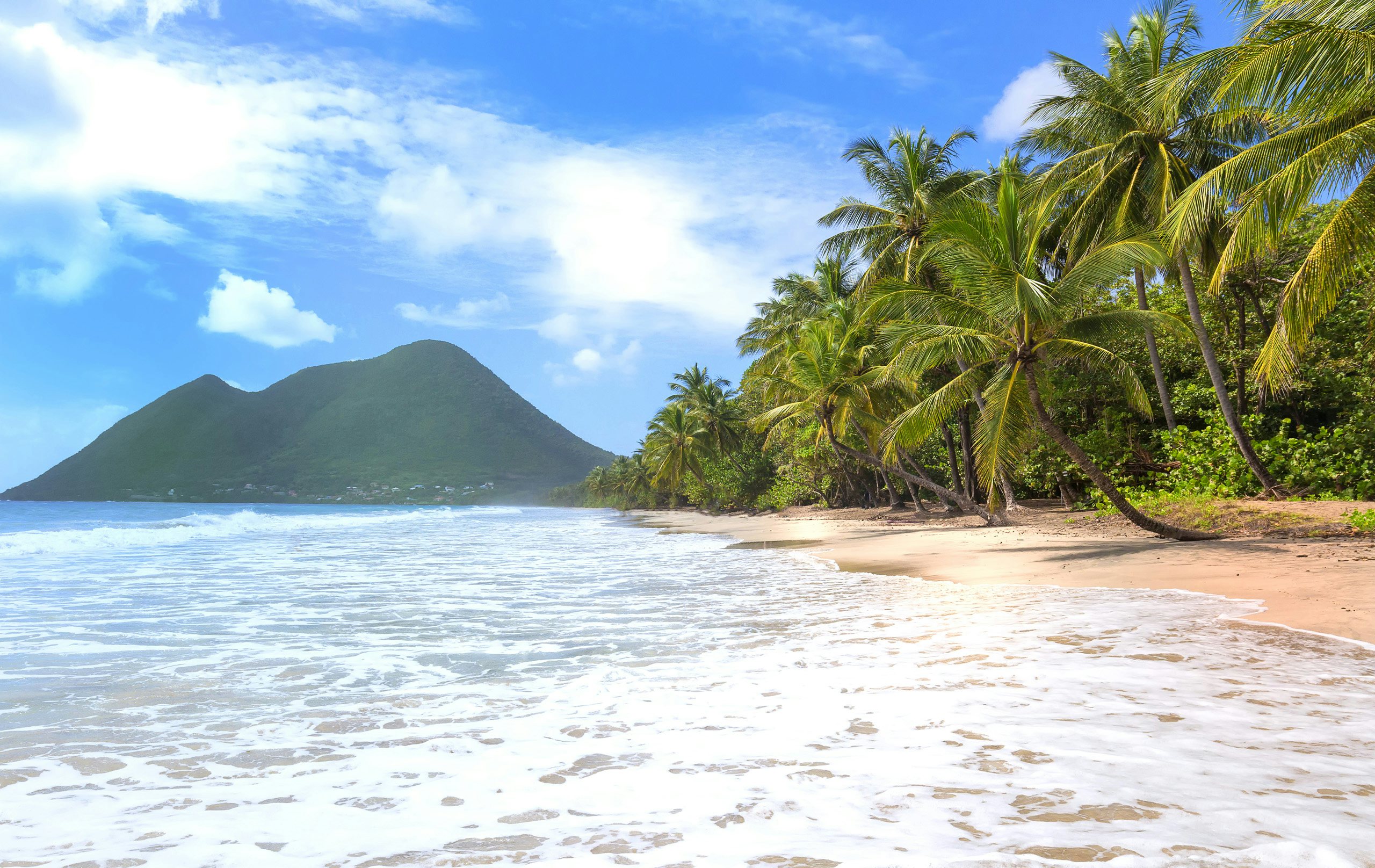 Martinique Yacht Charter - Caribbean_Windward_Martinique Martinique Yacht Charter - Caribbean_Windward_Martinique_waves lapping onto the sand with mountains in the distance