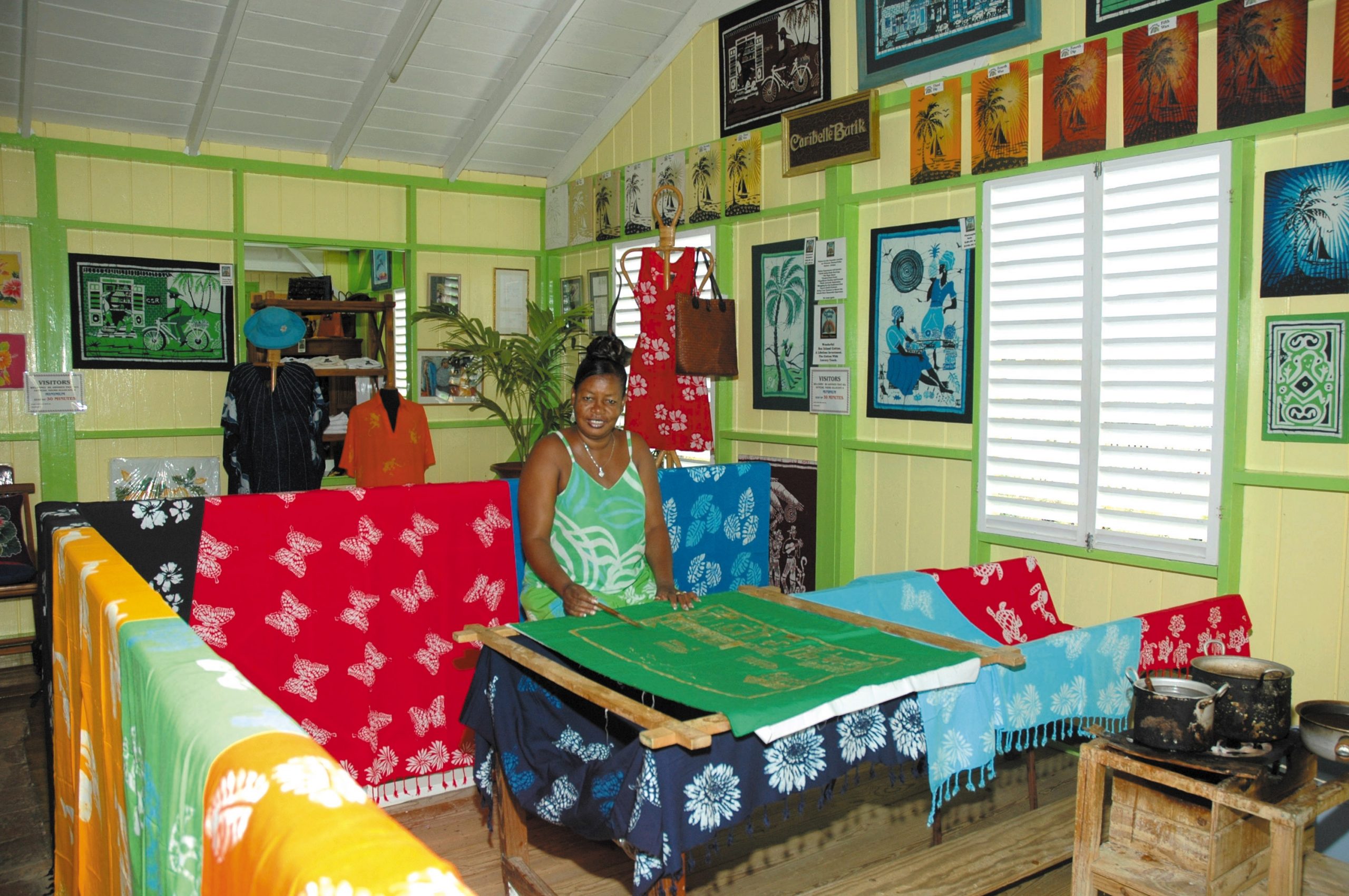 An artisan demonstrating how to make batik at the Caribelle Batik factory.