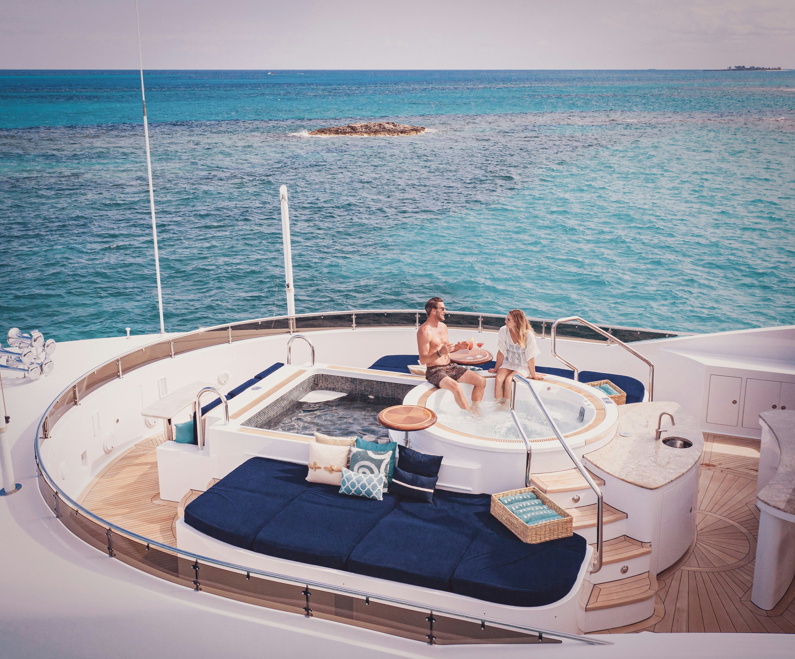Charter-Marketing_Running-Costs Couple sitting on edge of Jacuzz on board charter yacht in the Caribbeani