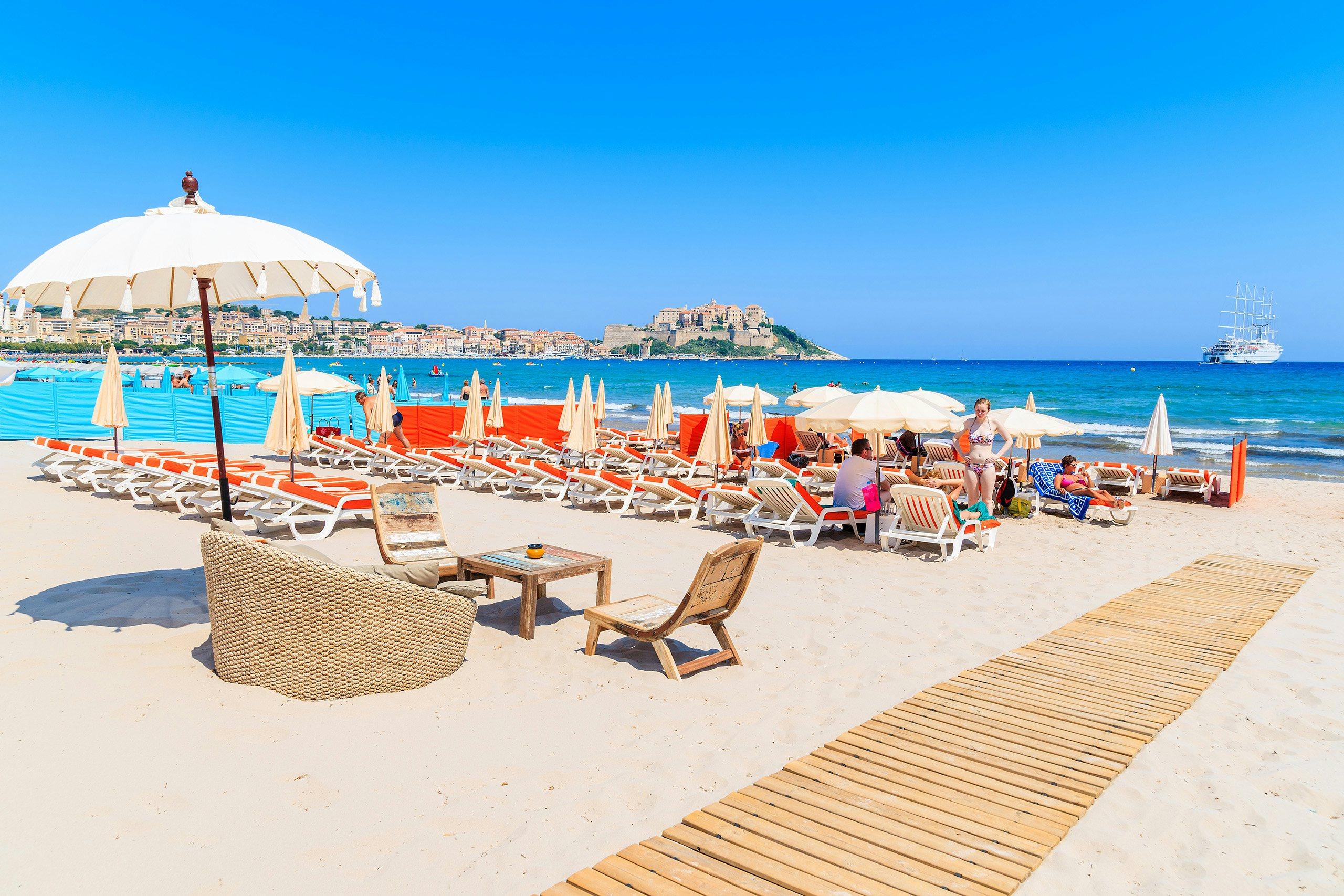 Calvi Beach Club Luxury | Chic Yacht Charter Destinations | Northrop & Johnson The vibrant Calvi Beach Club set against a backdrop of turquoise waters, inviting yacht charter visitors to indulge.