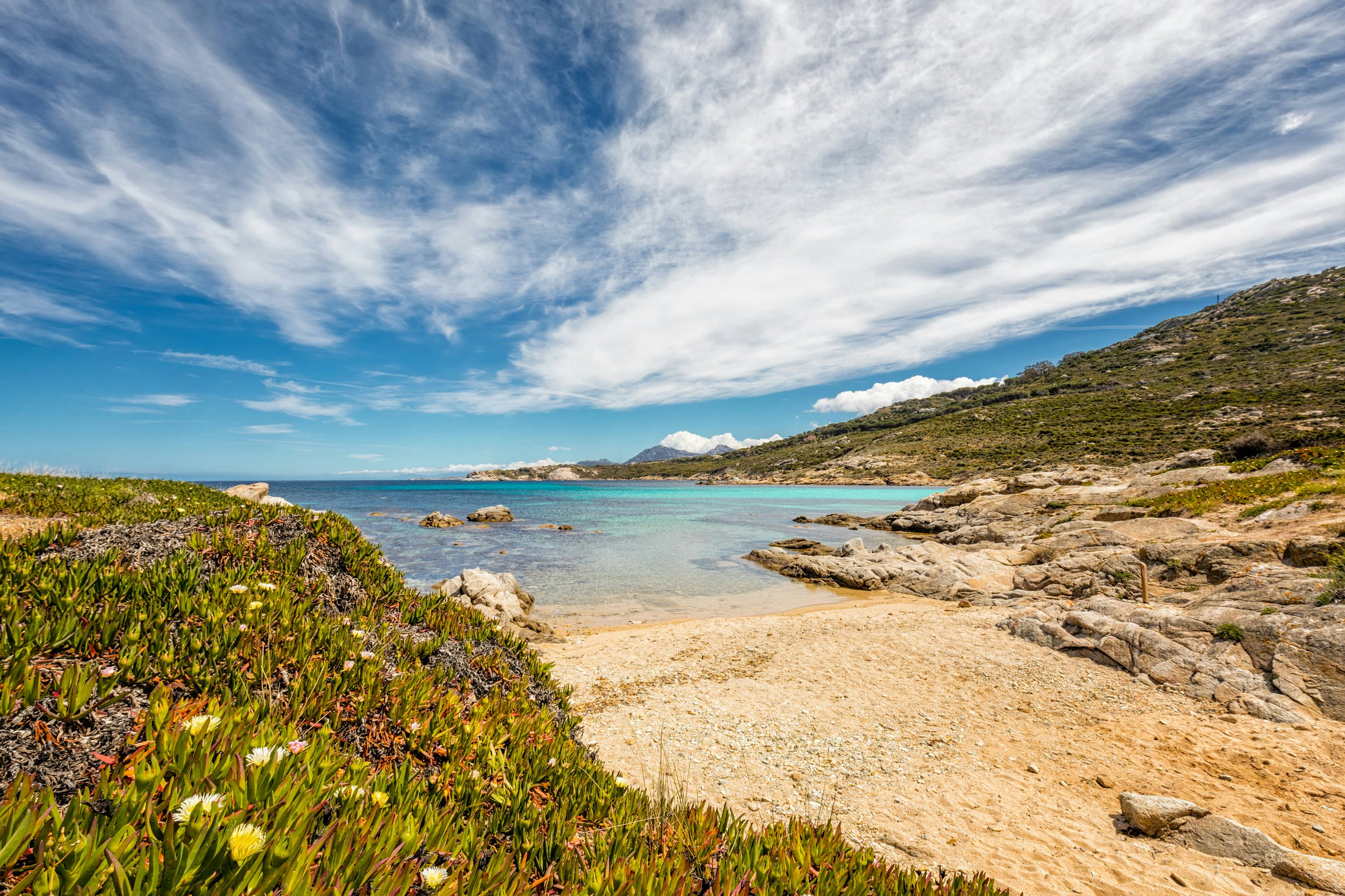 Calvi Beach Escape | Exclusive Corsican Yacht Charters | Northrop & Johnson Tranquil waters and sandy shores of Calvi Beach, a peaceful retreat for yacht charter guests.