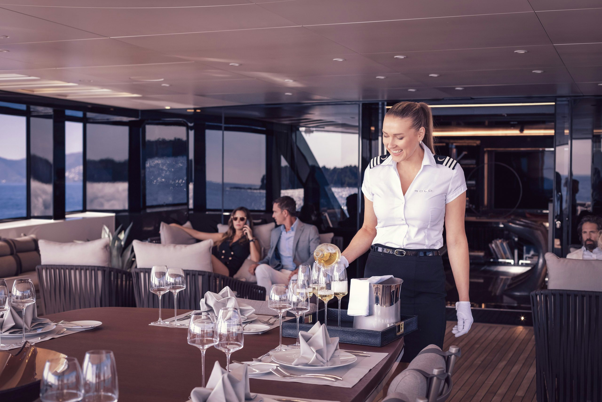 Crew-Placement-2 Stewardess serving champagne for couple on board charter yacht