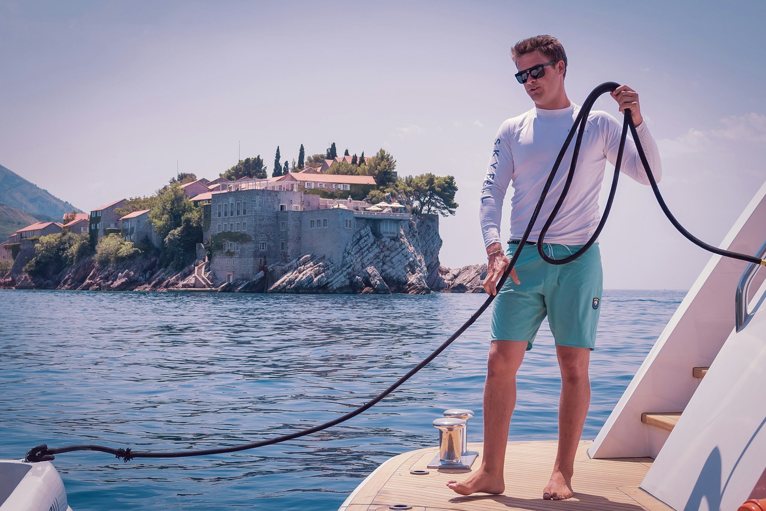 Deckhand pulling tender from swimming platform during Yacht Charter | N&J Deckhand pulling tender from swimming platform during Yacht Charter | N&J