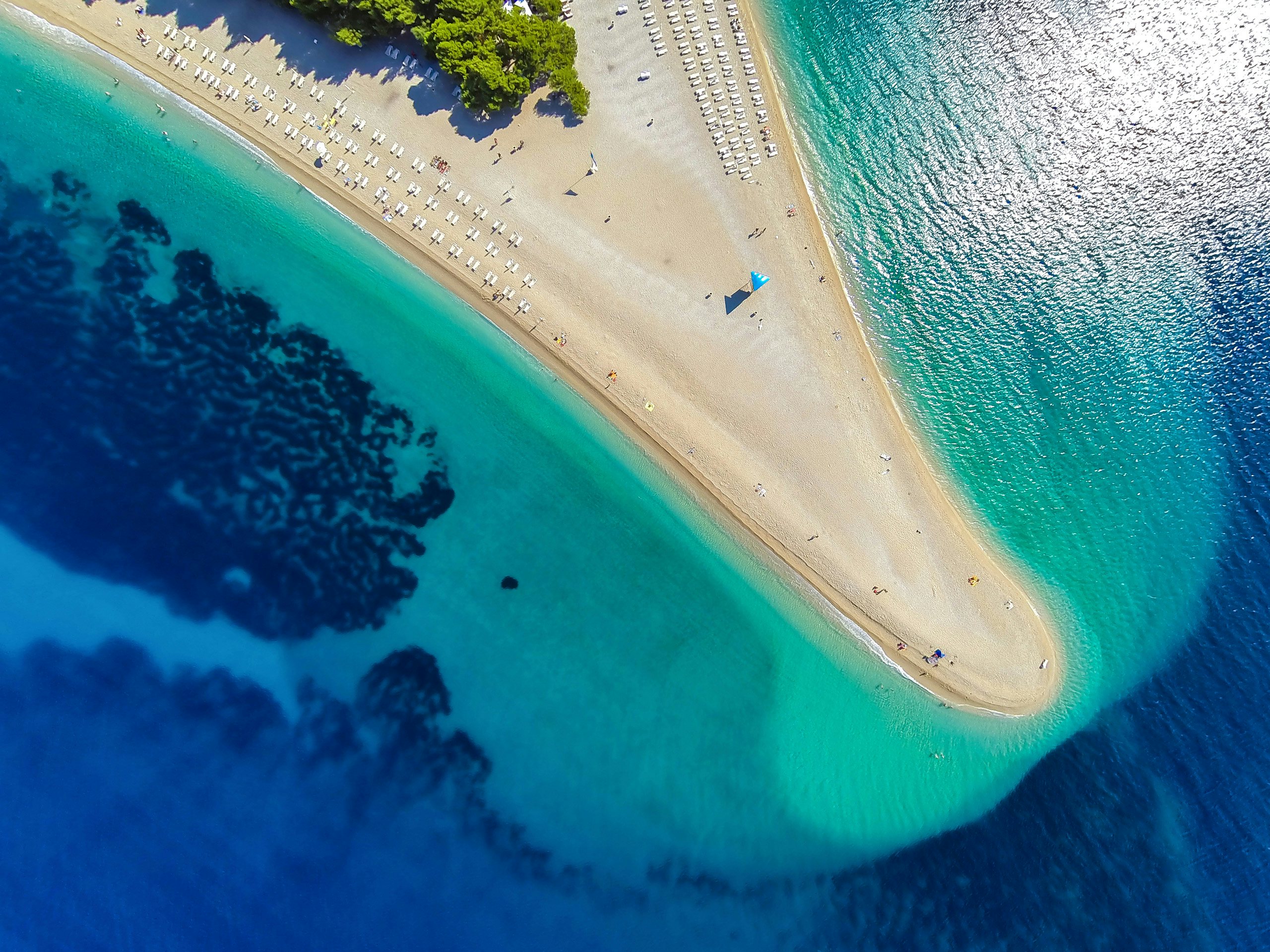 Croatia's Zlatni Rat - Iconic Beach Awaits Yacht Charter Guests Aerial view of the stunning Zlatni Rat Beach, with its unique shape and crystal-clear waters, a yachting jewel in Croatia.
