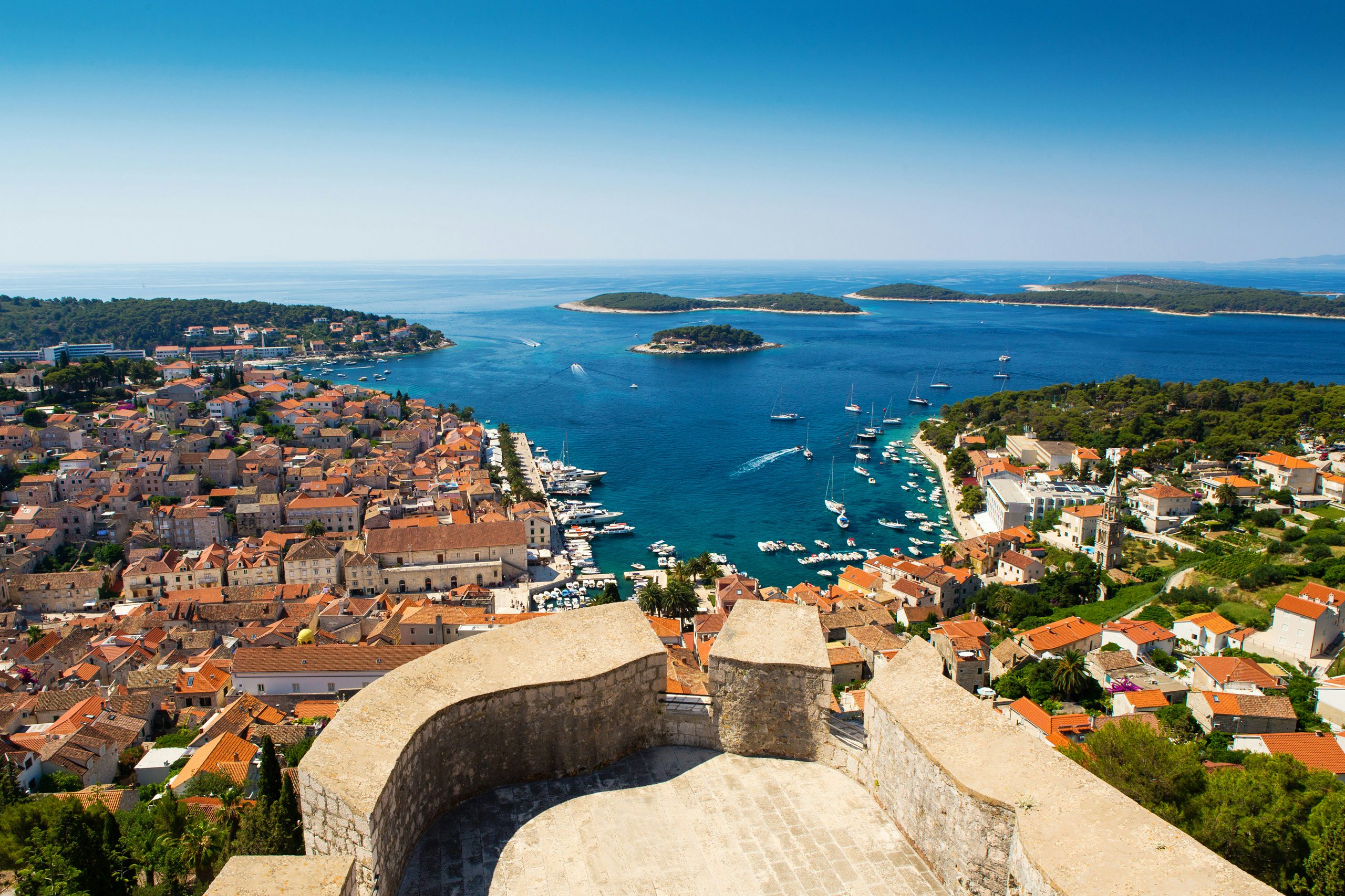 Aerial view of Hvar island, showcasing the dense terra-cotta rooftops and crystal-clear Adriatic waters.