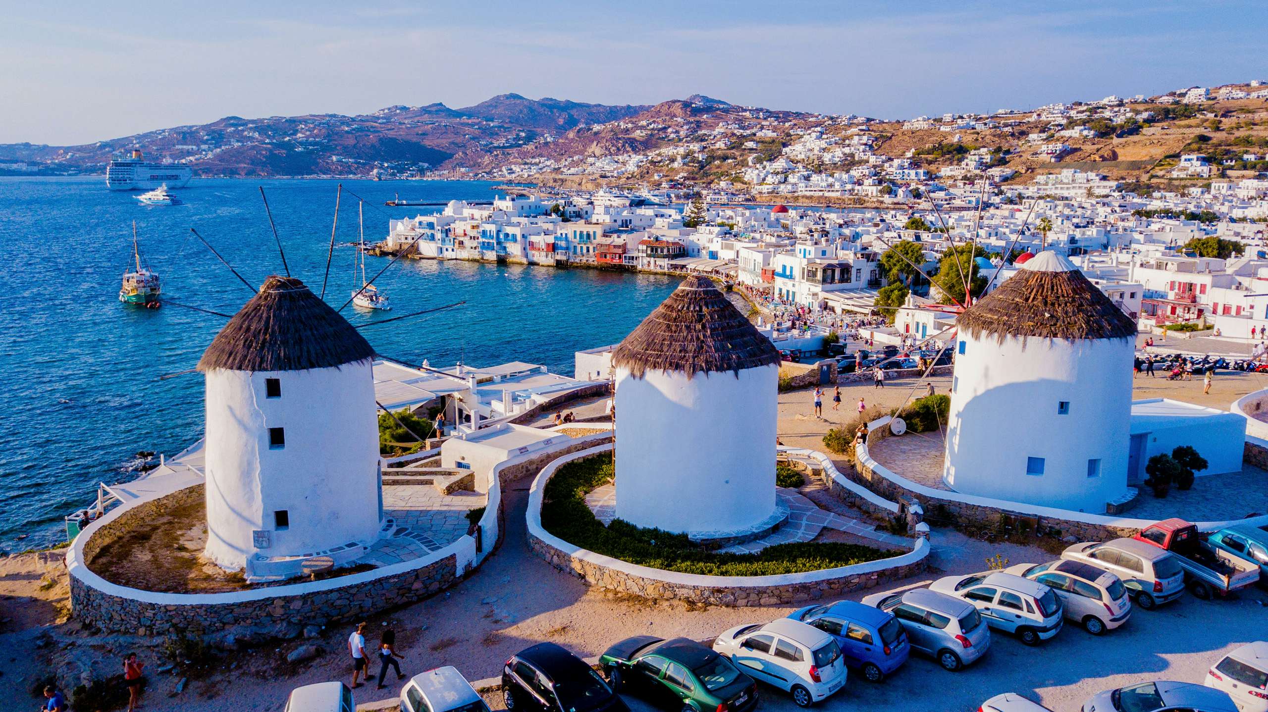 The famous windmills of Mykonos overlooking the harbor, a signature sight on a luxury Cyclades yacht journey.