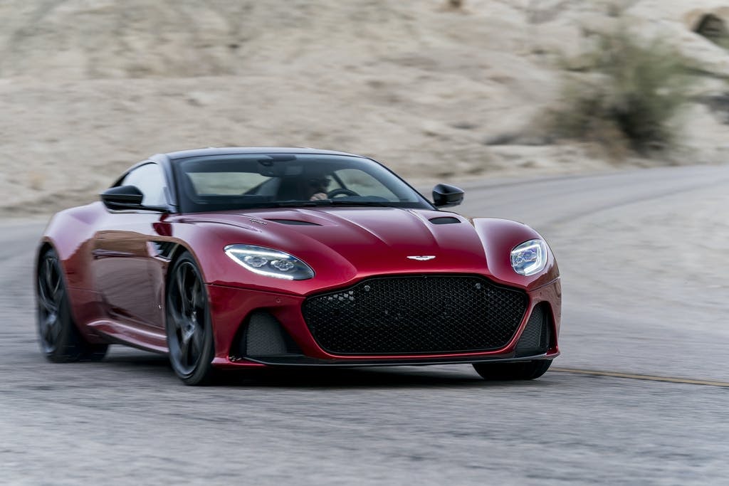 Aston Martin DBS Superleggera in red going down a road