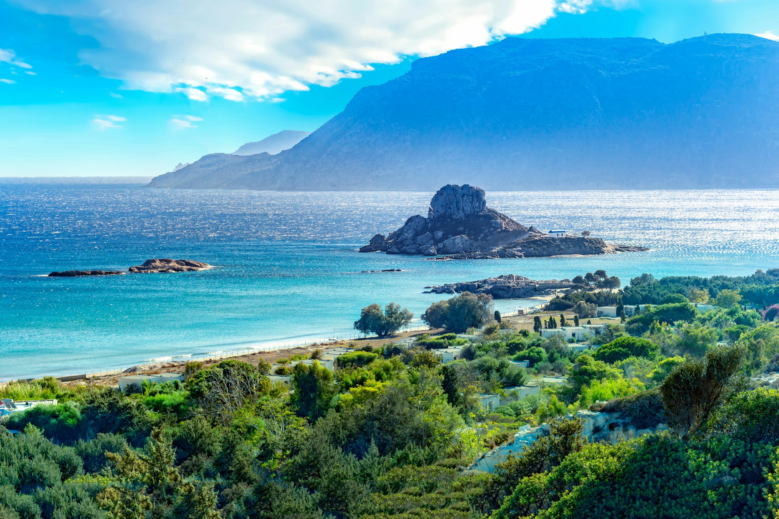 Kefalos Village, Kos - Discover Dodecanese Charm | Yacht Charter Odyssey Sunset casting golden hues over the rugged cliffs and coastline of Kefalos Village in Kos, a yacht charter haven