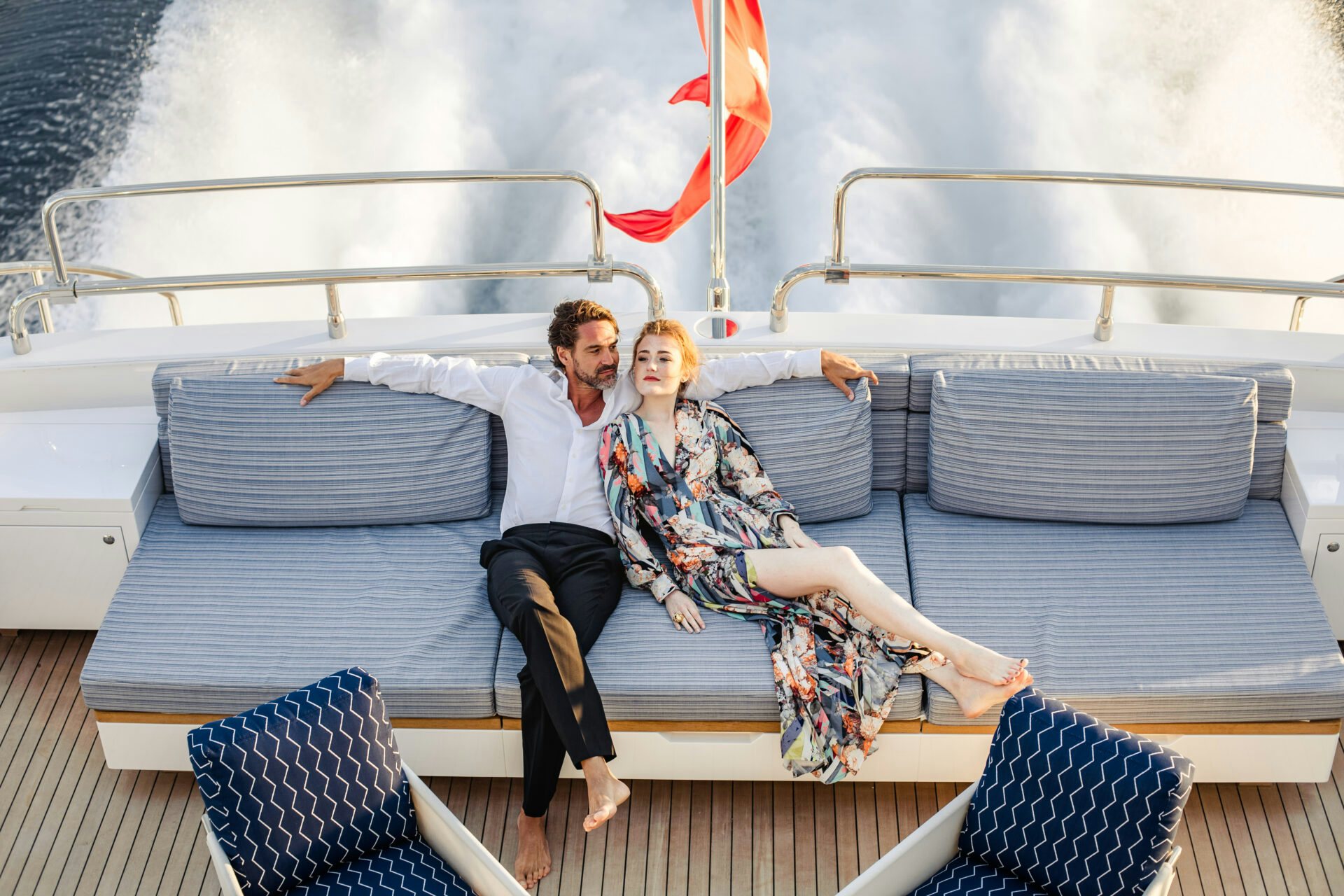 Young couple relaxing on the back of a yacht deck Young couple relaxing on the back of a yacht deck