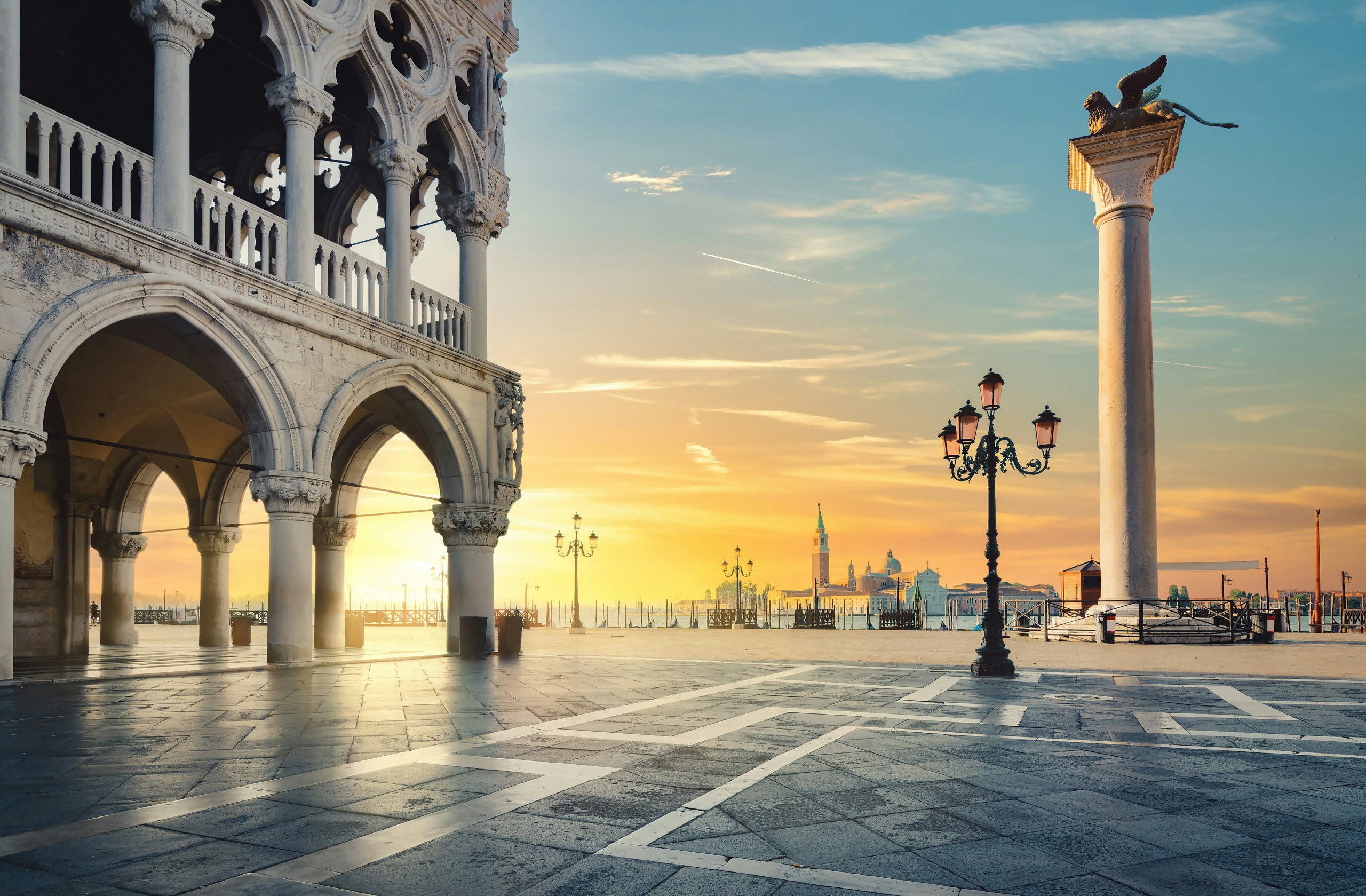 Sunrise over the historic architecture of Venice with empty piazzas and a serene sky.