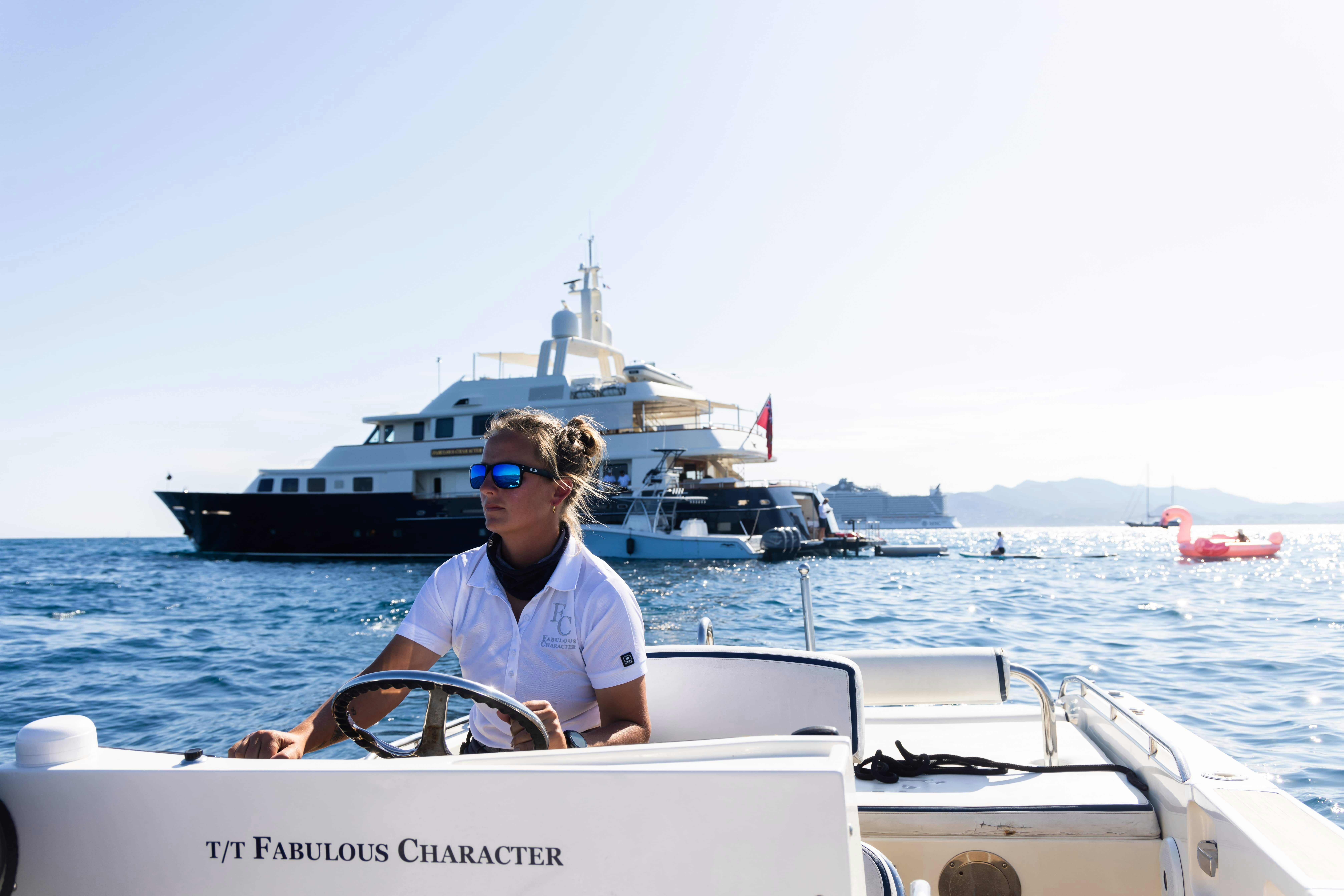 Fabulous charter yacht in the ocean from the tender view with a crewmember driving