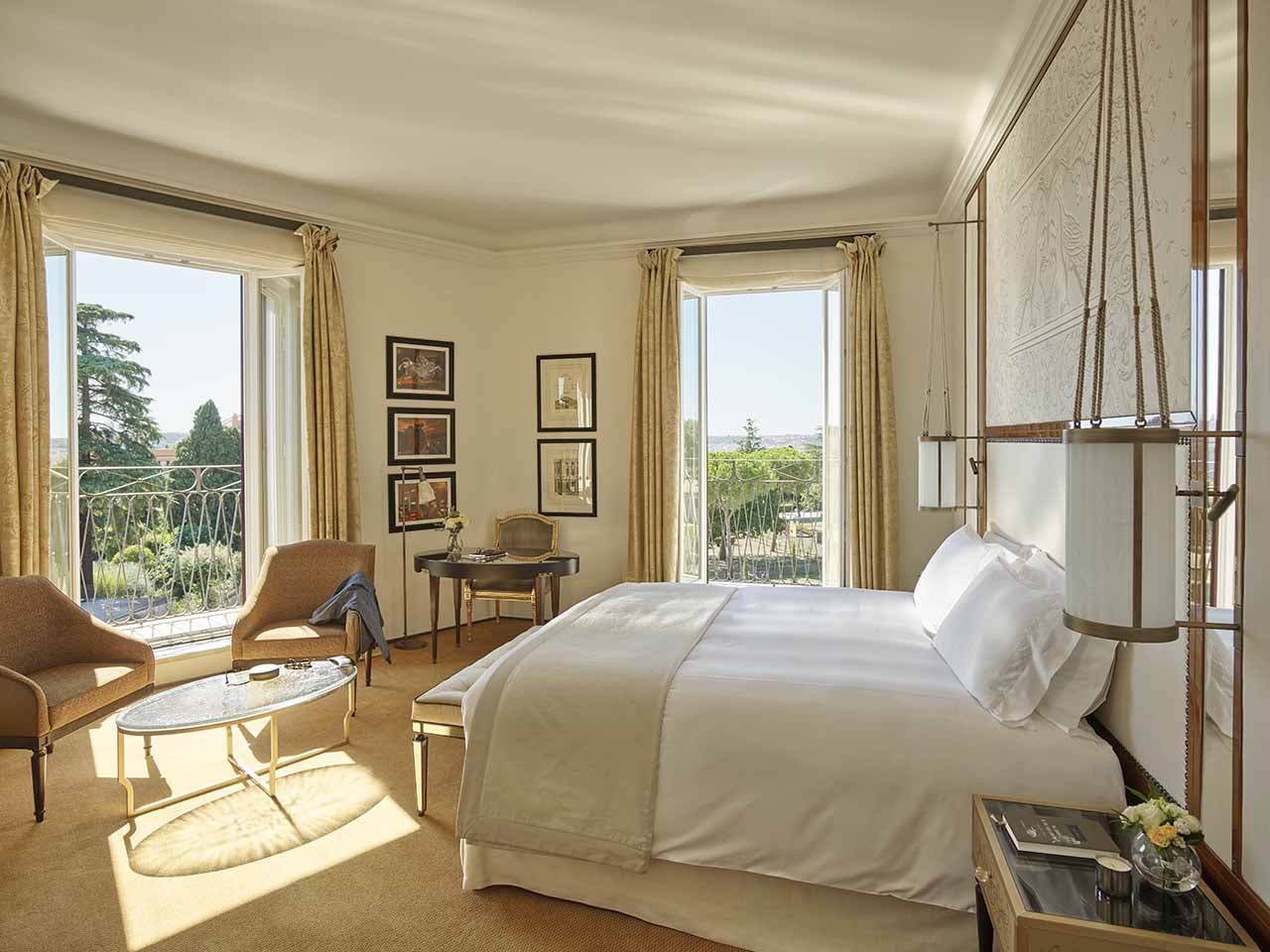 A spacious hotel room with a large bed and view over Rome