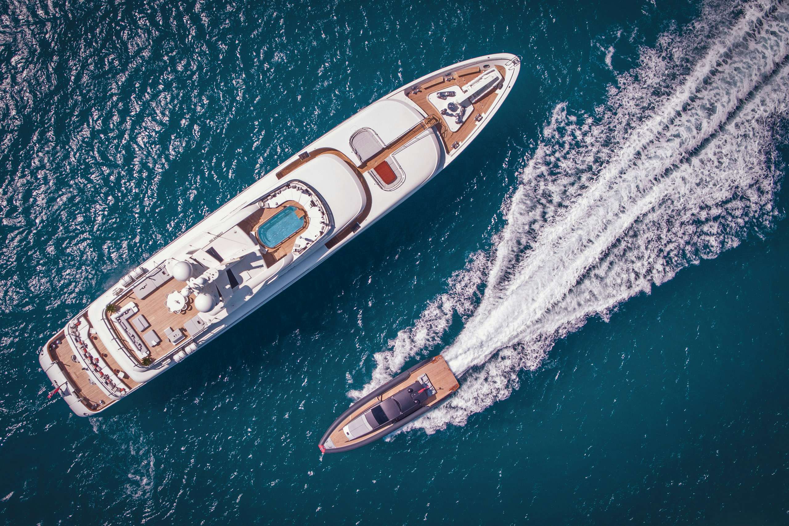 Tender passing by superyacht at anchor