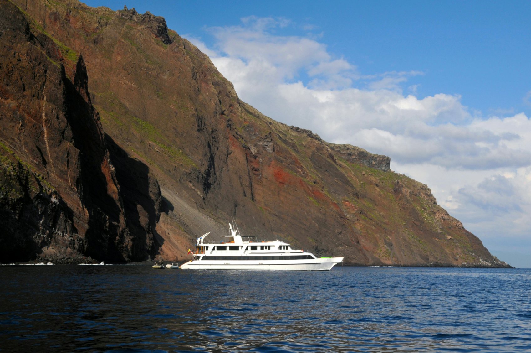 Integrity luxury yacht charter in Galapagos off rocky coast