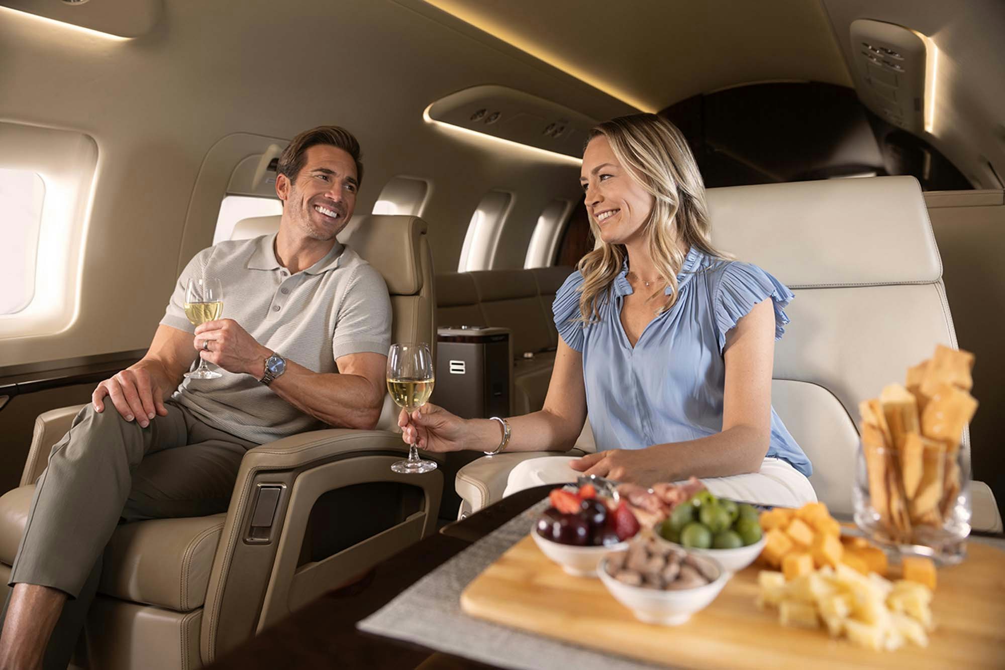 image of a couple sitting on a private jet toasting champagne