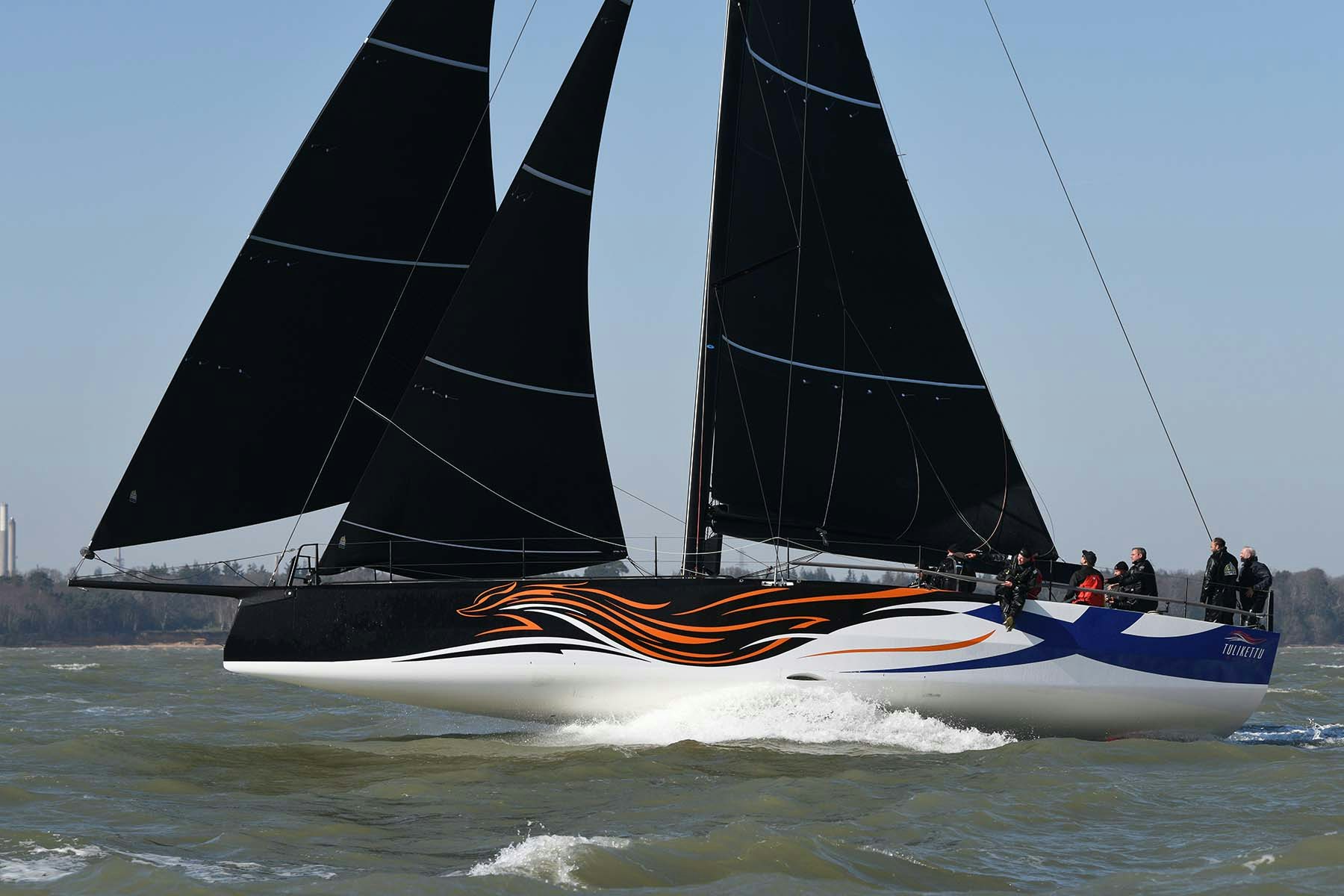 infiniti 52 sailing yacht with dramatic black sails in the ocean