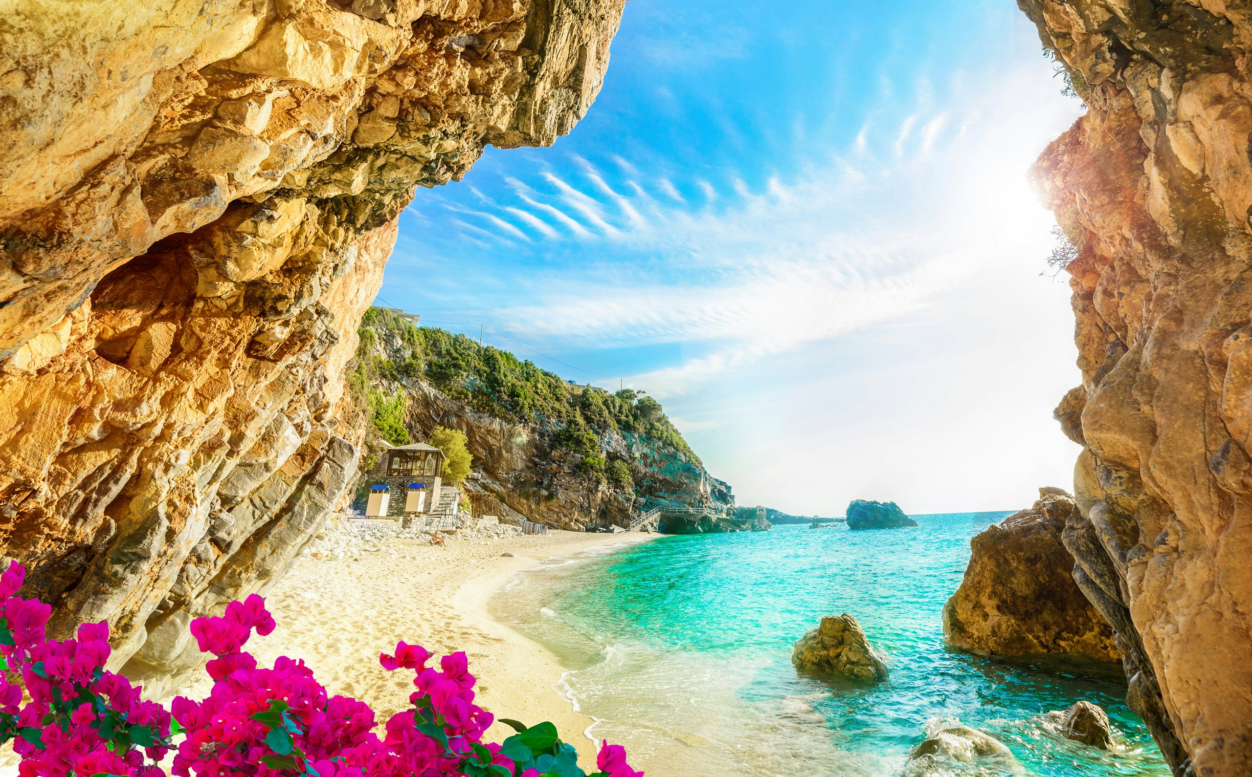 Secluded beach in Corfu with azure waters, hidden beneath a rocky cove, accessible by a luxury yacht.