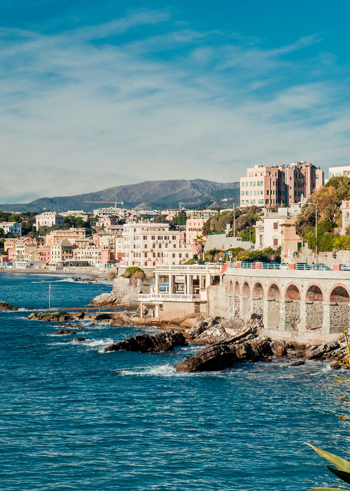 The historic waterfront of Genoa, with its renowned architecture, as seen from the Italian Riviera yacht route.