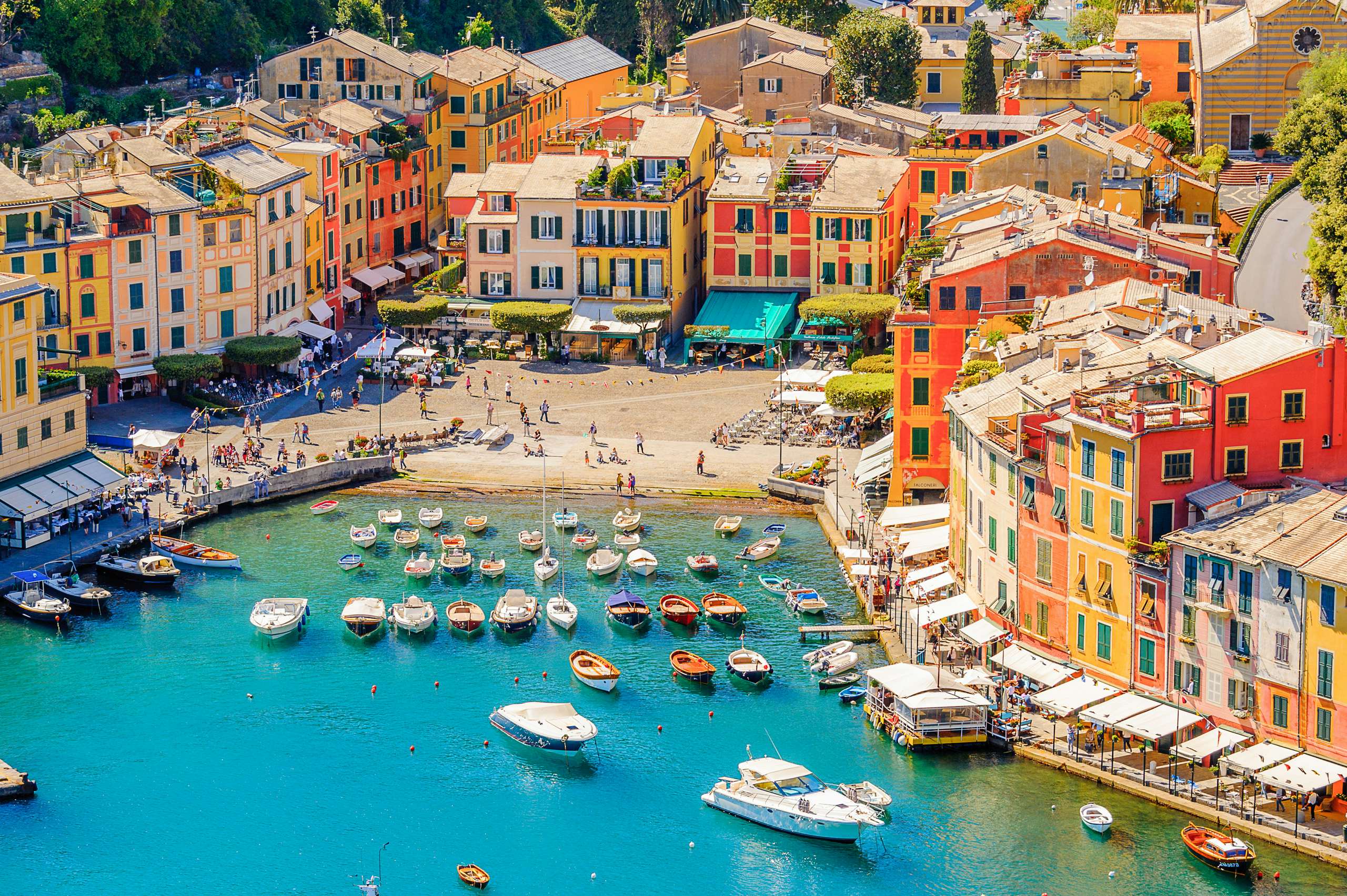 Vibrant harbor of Portofino with colorful buildings and luxury yachts, epitomizing Italian Riviera elegance.